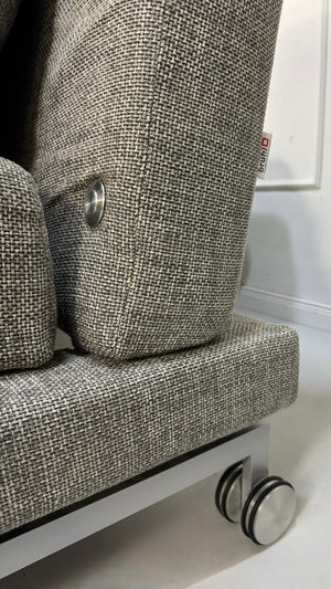 Refurbished graues Brühl Moule Designer Stoff Sofa vor einer Wand, stilvoll und modern eingerichtet.