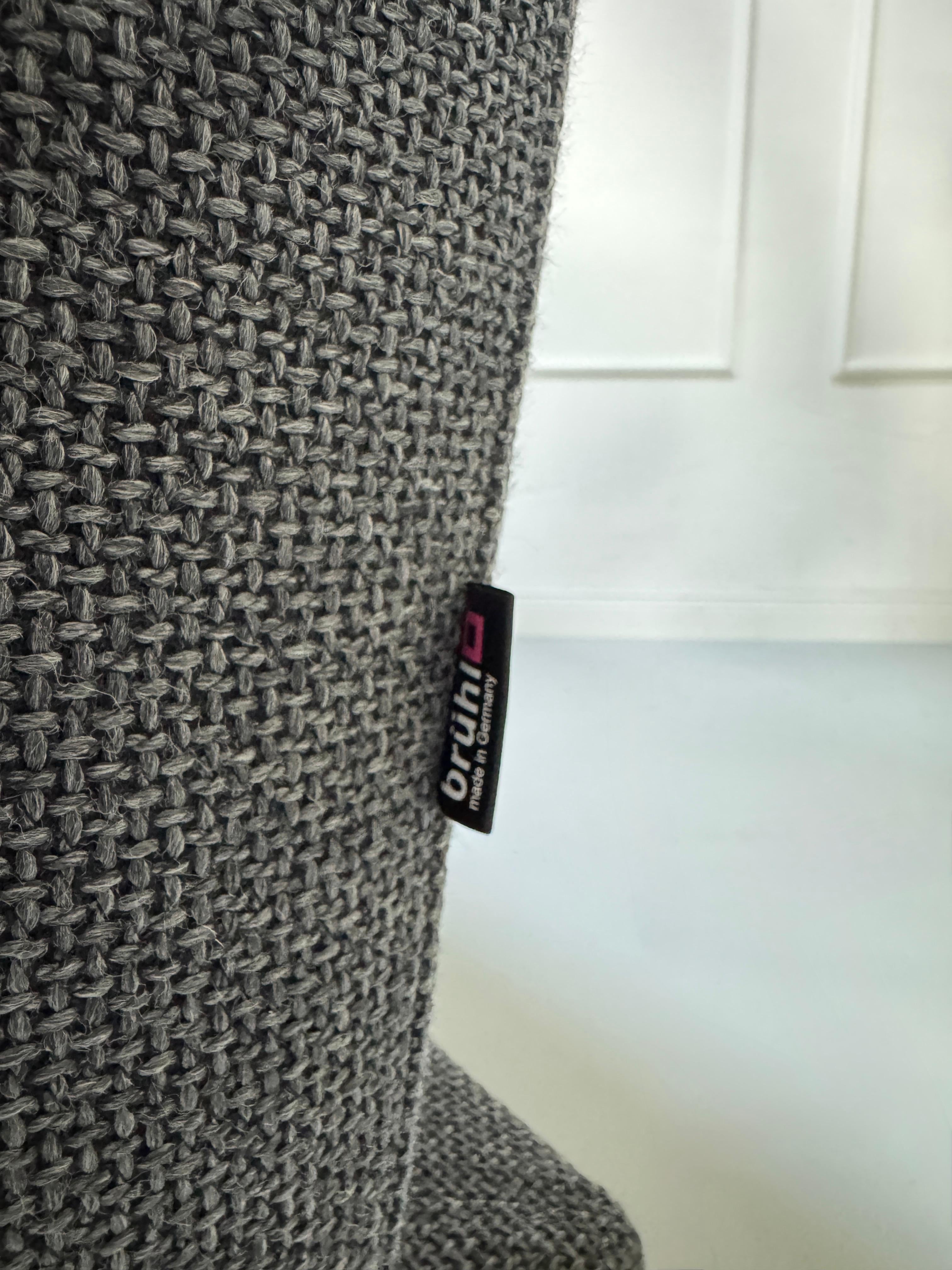 Graues Ausstellungsstück Brühl Moule Designer Stoff Sofa vor einer Wand, stilvoll und modern eingerichtet.