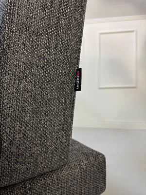 Anthrazit Brühl Moule Small Designer Stoff Sofa vor einer Wand, stilvoll und modern eingerichtet.