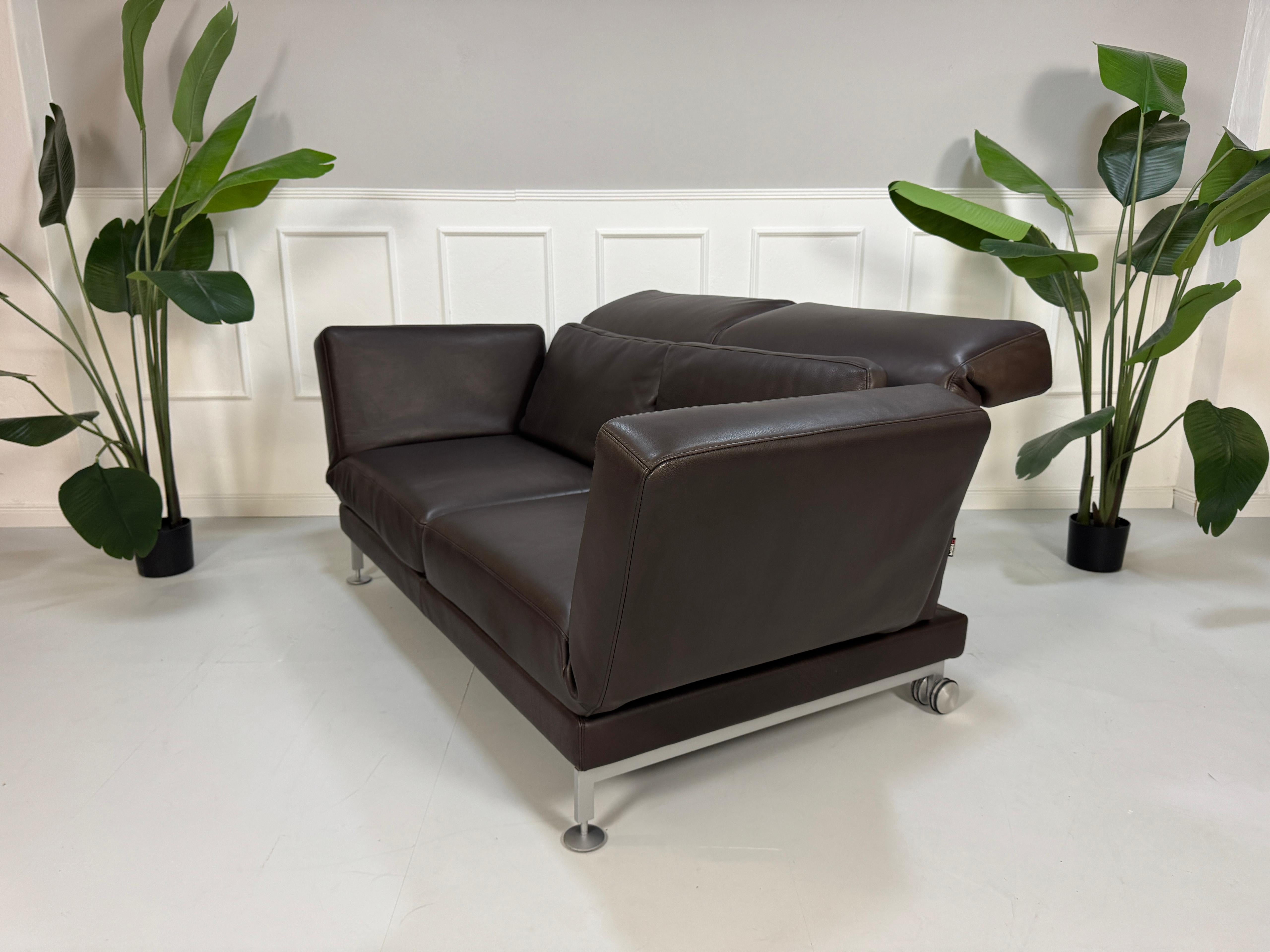 Gebrauchtes Brühl Moule 2-Sitzer Leder Sofa in der Farbe Braun vor einer Wand, stilvoll und modern eingerichtet.