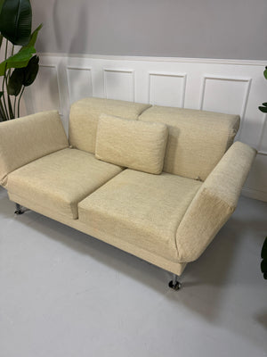 Gebrauchtes Brühl Moule Stoff Sofa in der Farbe Beige vor einer Wand, stilvoll und modern eingerichtet.