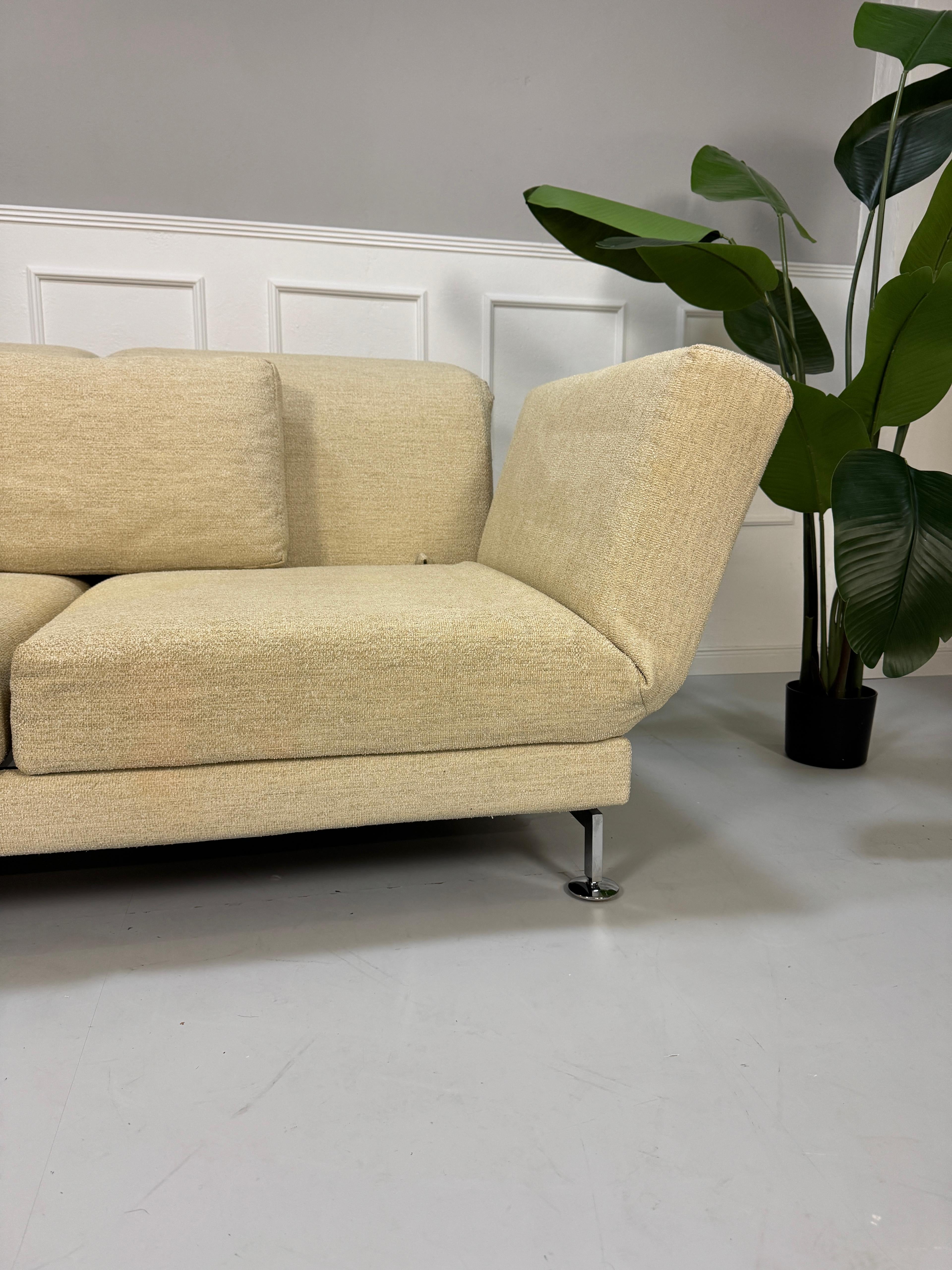 Gebrauchtes Brühl Moule Stoff Sofa in der Farbe Beige vor einer Wand, stilvoll und modern eingerichtet.