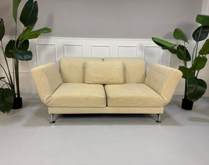 Gebrauchtes Brühl Moule Stoff Sofa in der Farbe Beige vor einer Wand, stilvoll und modern eingerichtet.