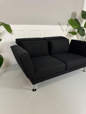 Gebrauchtes Brühl Moule 2-Sitzer Stoff Sofa in der Farbe Schwarz vor einer Wand, stilvoll und modern eingerichtet.