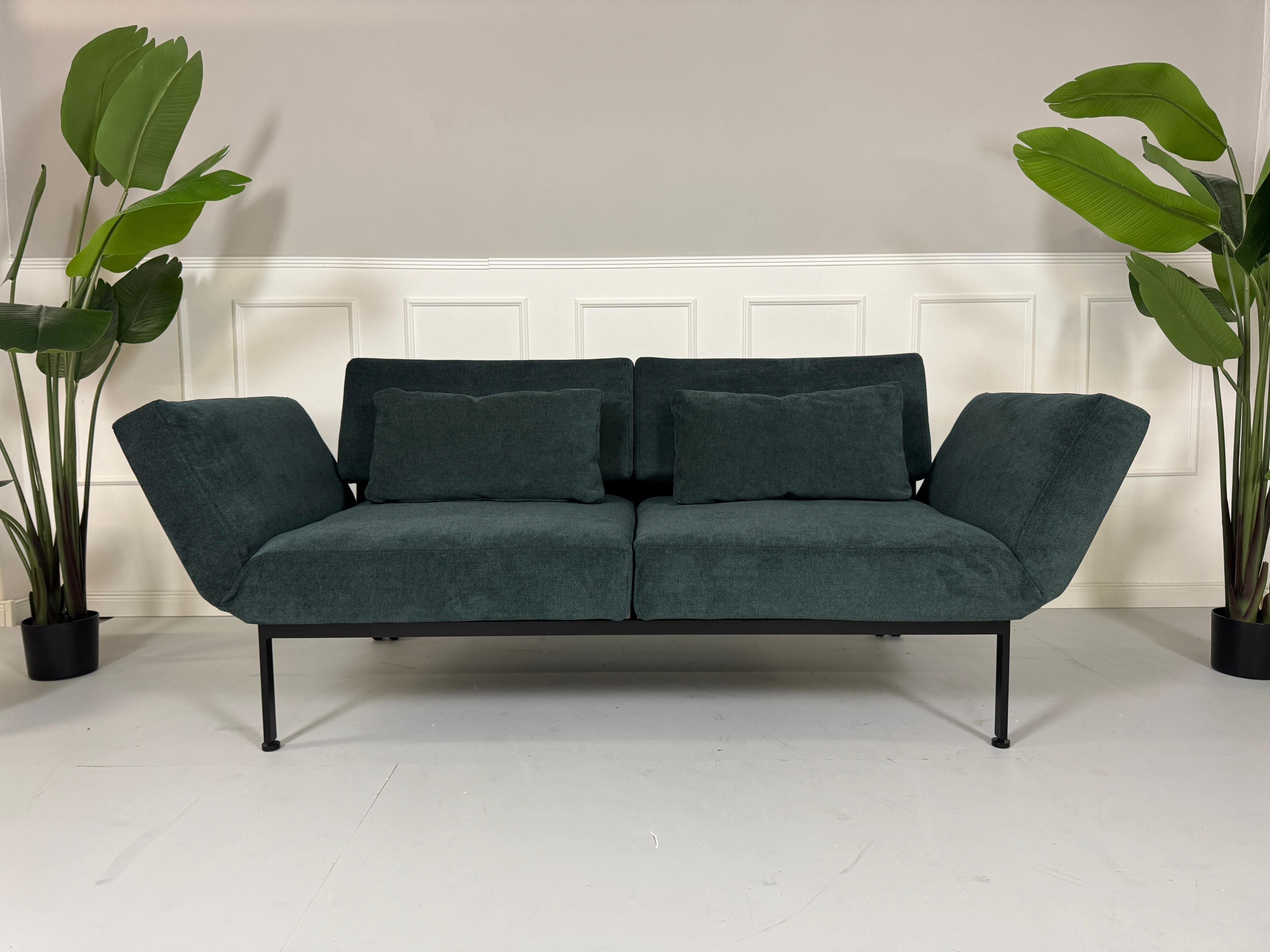 Gebrauchtes Brühl Roro Soft Stoff Sofa in der Farbe Blau vor einer Wand, stilvoll und modern eingerichtet.