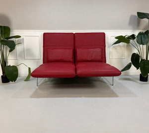 Gebrauchtes rotes Brühl Roro Designer Leder Sofa vor einer Wand, stilvoll und modern eingerichtet.