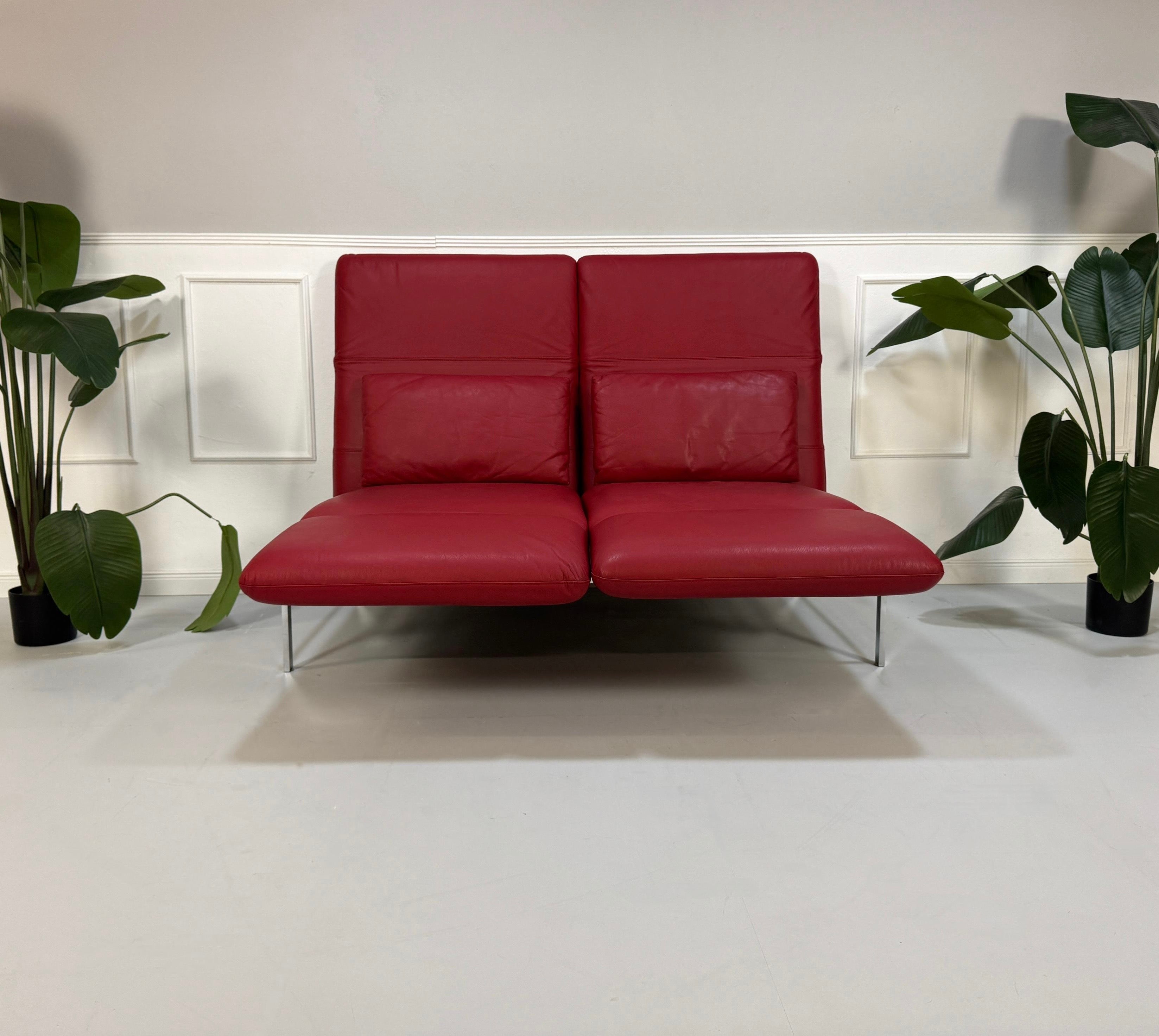 Gebrauchtes rotes Brühl Roro Designer Leder Sofa vor einer Wand, stilvoll und modern eingerichtet.