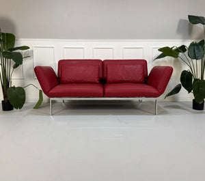 Gebrauchtes rotes Brühl Roro Designer Leder Sofa vor einer Wand, stilvoll und modern eingerichtet.
