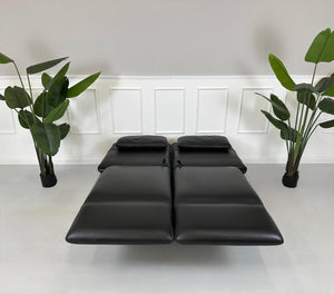 Gebrauchtes schwarzes Brühl Roro Designer Leder Sofa vor einer Wand, stilvoll und modern eingerichtet.