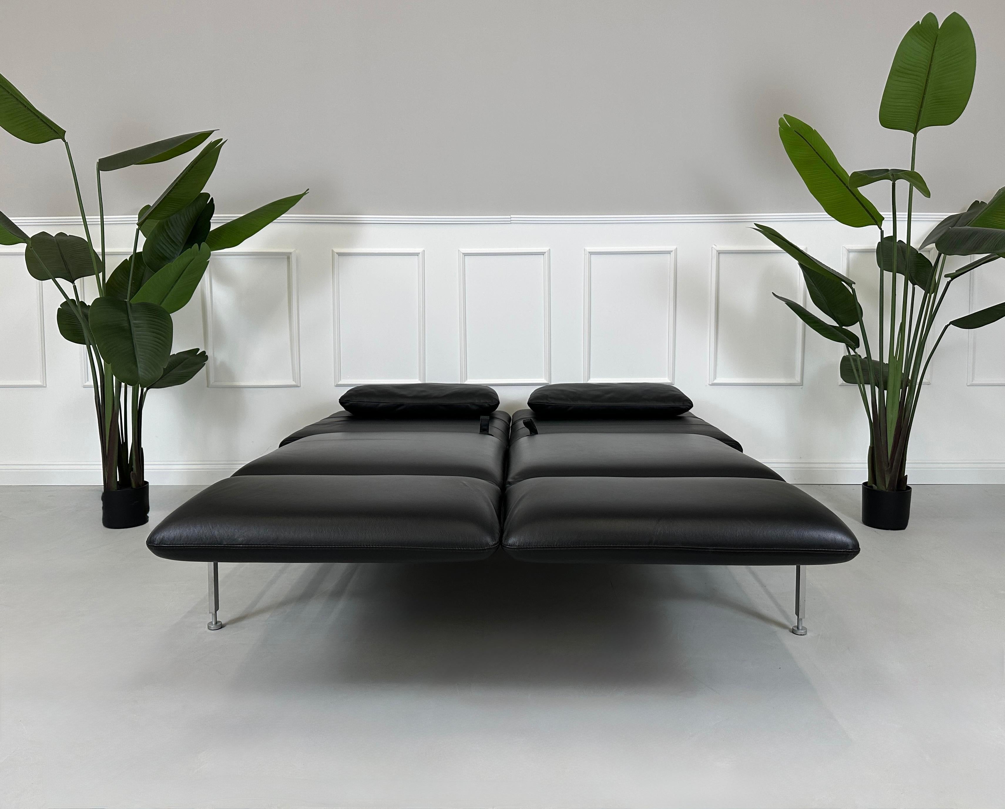 Gebrauchtes schwarzes Brühl Roro Designer Leder Sofa vor einer Wand, stilvoll und modern eingerichtet.