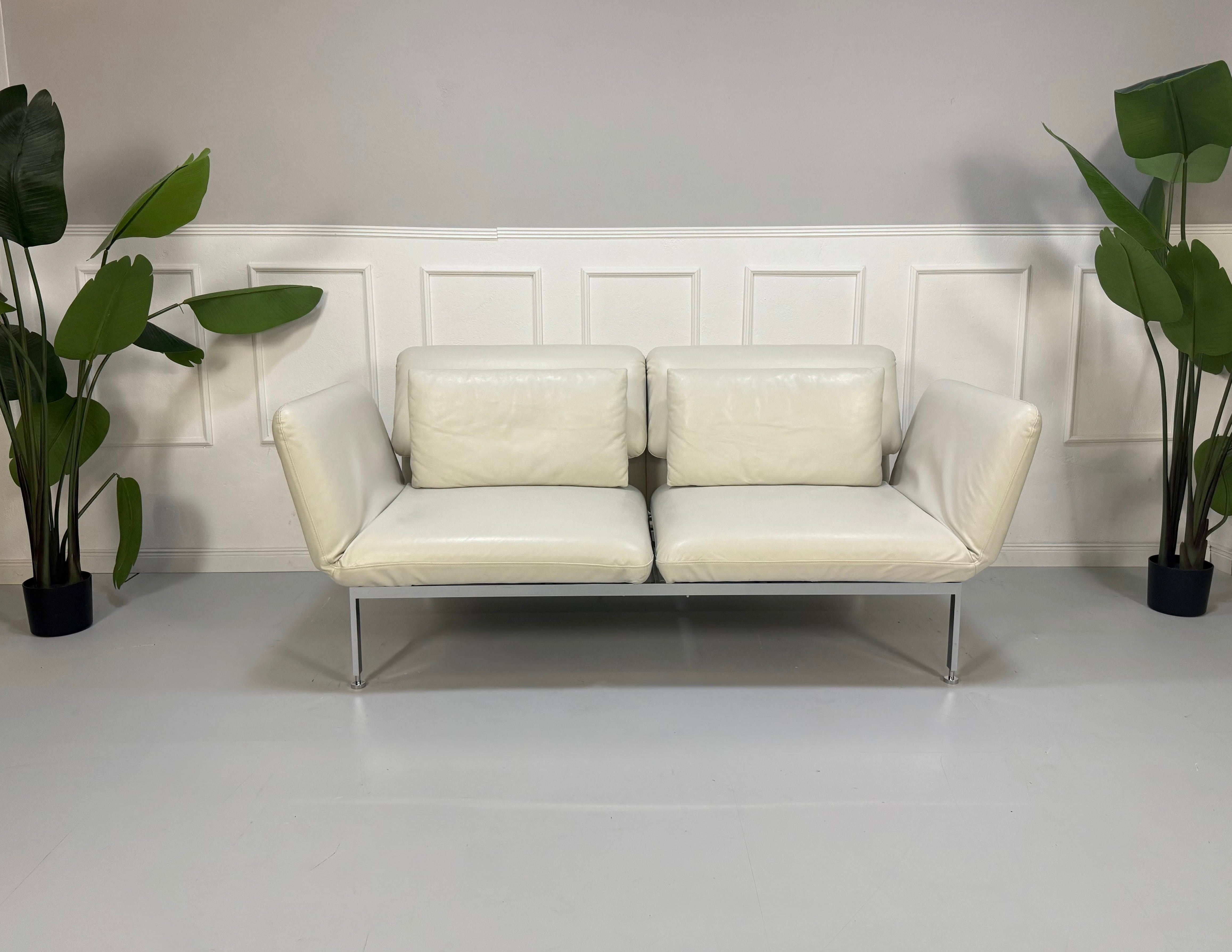 Gebrauchtes weißes Brühl Roro Designer Leder Sofa vor einer Wand, stilvoll und modern eingerichtet.