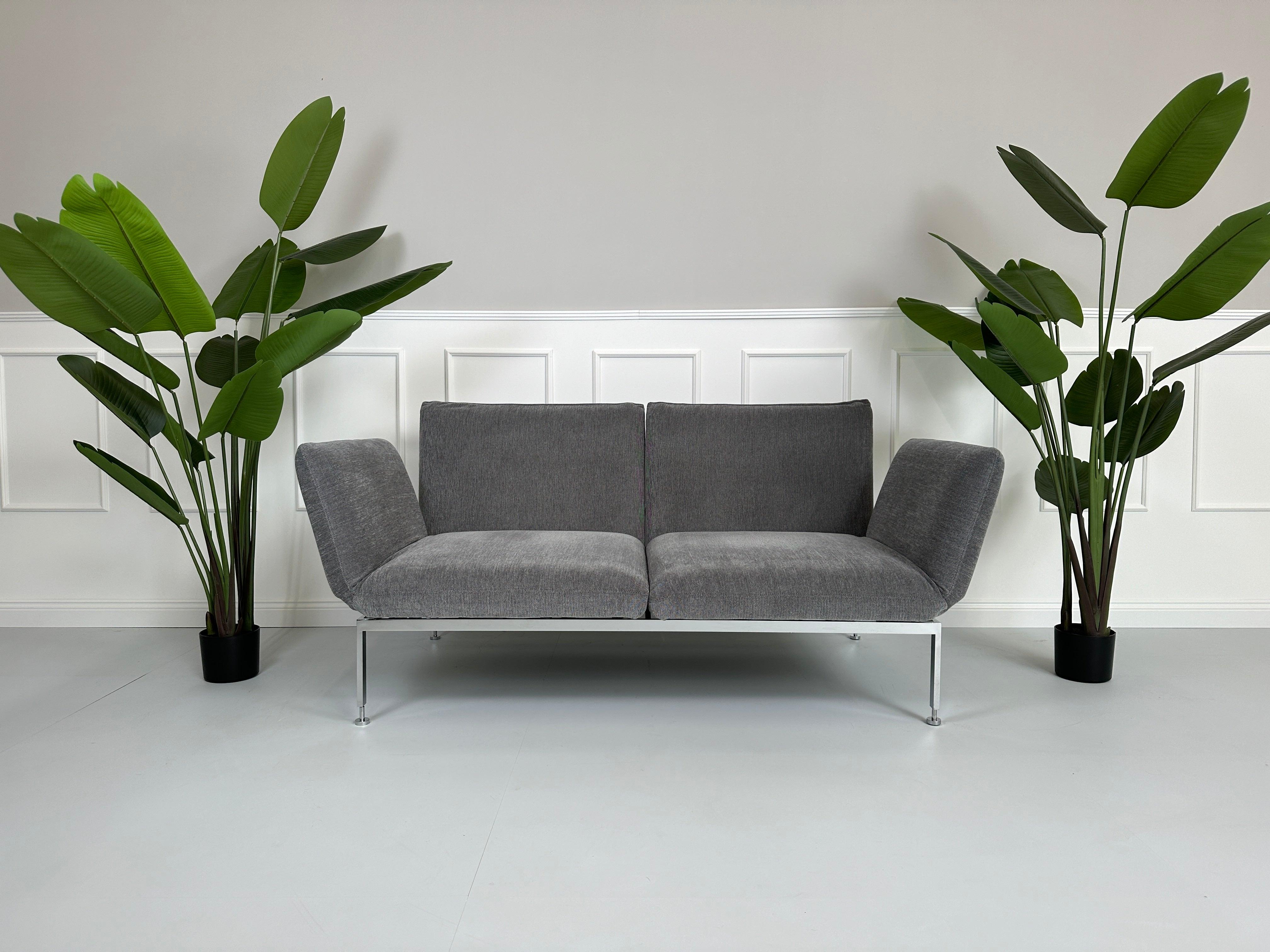 Gebrauchtes Brühl Roro Stoff Sofa in der Farbe Grau vor einer Wand, stilvoll und modern eingerichtet.