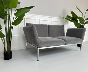 Gebrauchtes Brühl Roro Stoff Sofa in der Farbe Grau vor einer Wand, stilvoll und modern eingerichtet.