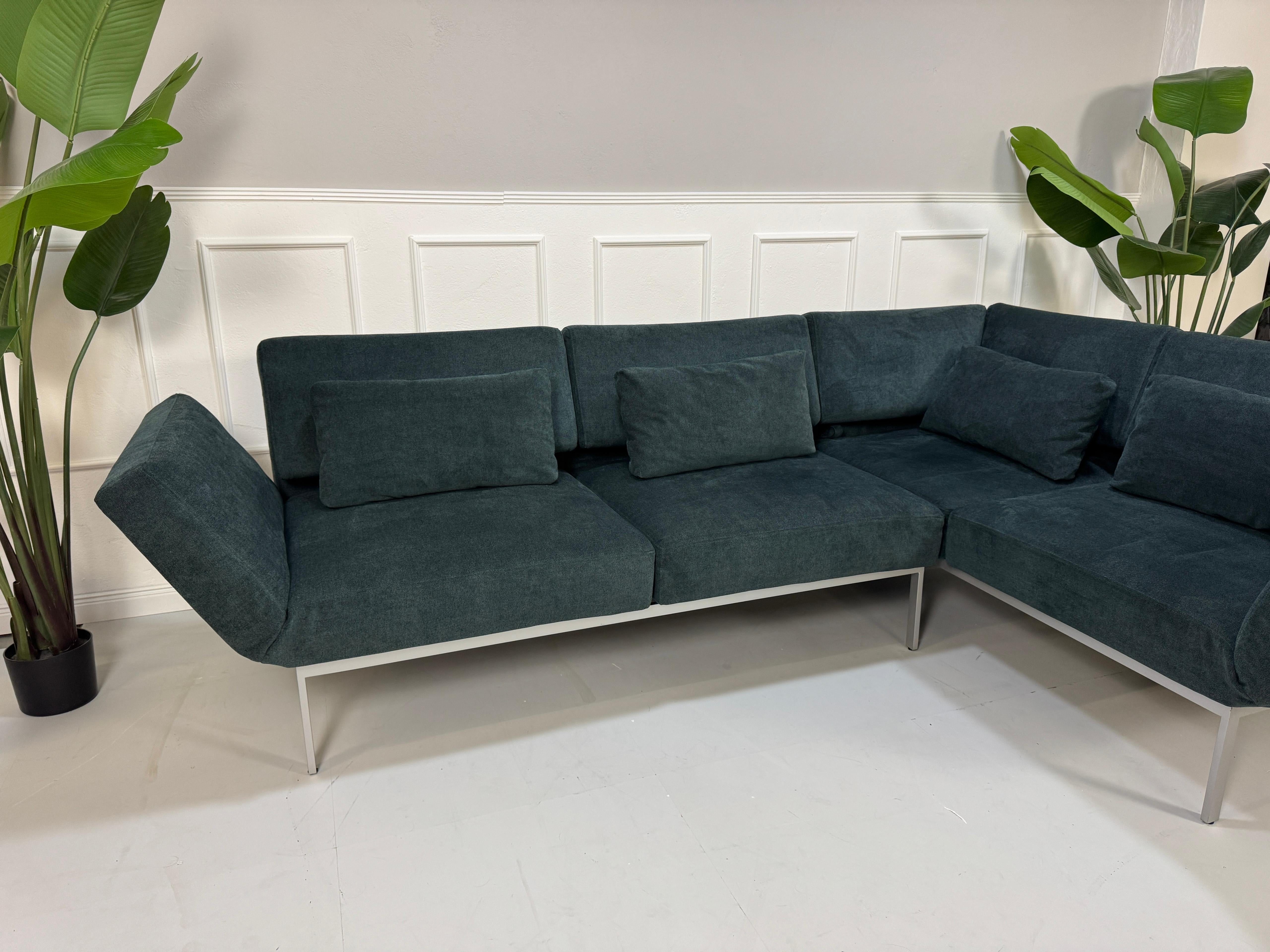 Gebrauchtes Brühl Roro Soft Stoff Ecksofa in der Farbe Blau vor einer Wand, stilvoll und modern eingerichtet.