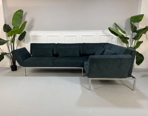 Gebrauchtes Brühl Roro Soft Stoff Ecksofa in der Farbe Blau vor einer Wand, stilvoll und modern eingerichtet.