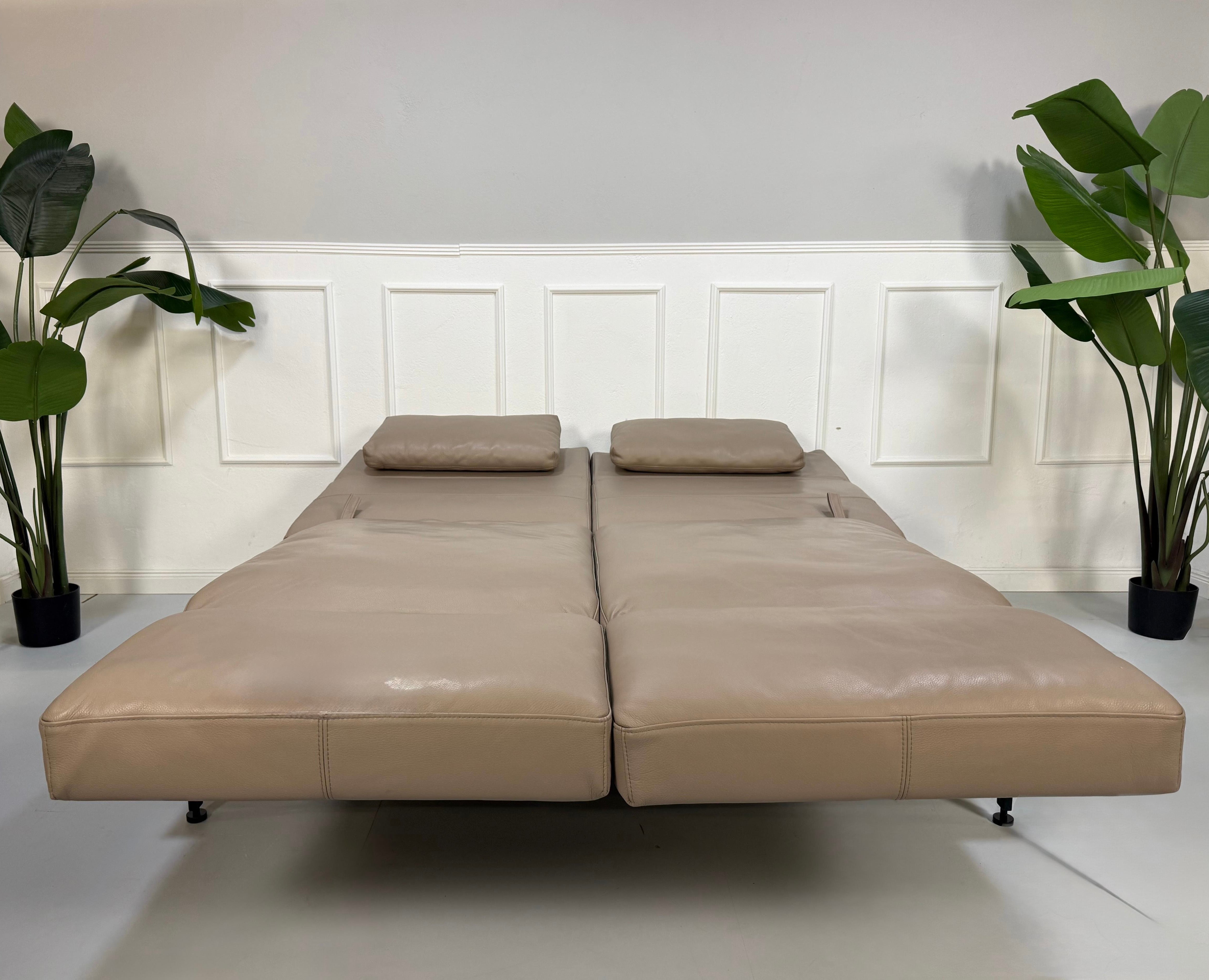 Erneuertes graues Brühl Roro Soft Designer Stoff Sofa vor einer Wand, stilvoll und modern eingerichtet.