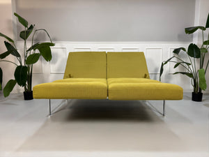 Gebrauchtes grünes Brühl Roro Soft Designer Stoff Sofa vor einer Wand, stilvoll und modern eingerichtet.