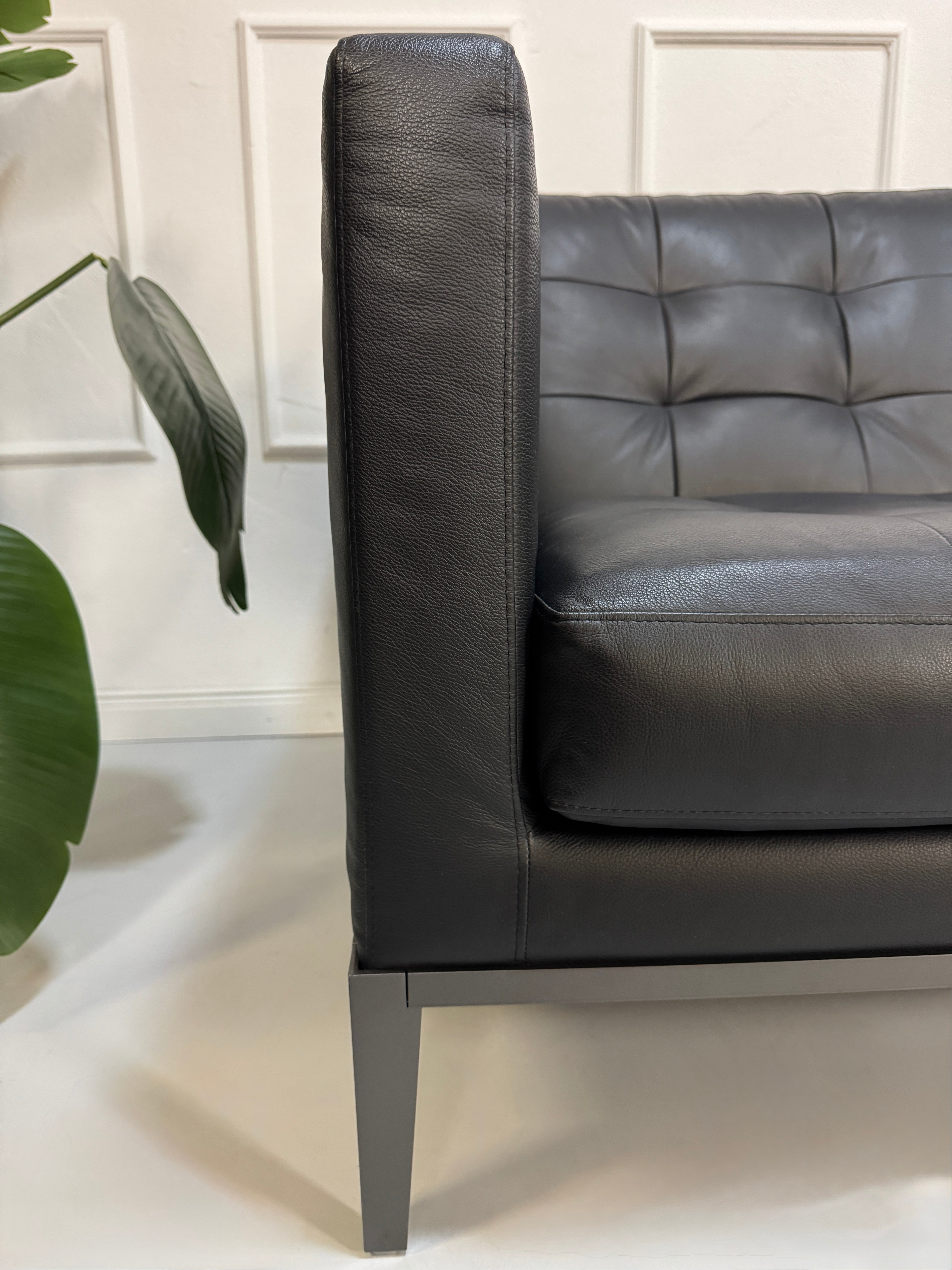 Gebrauchtes schwarzes B&B Italia AC Lounge Designer Leder Sofa vor einer Wand, stilvoll und modern eingerichtet.