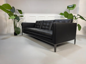 Gebrauchtes schwarzes B&B Italia AC Lounge Designer Leder Sofa vor einer Wand, stilvoll und modern eingerichtet.