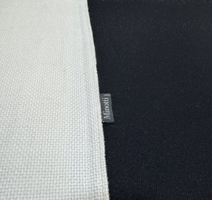 Gebrauchtes weißes Stoff Sofa Minotti Hamilton vor einer modernen Wand.