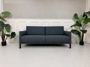 Gebrauchte graue Rolf Benz Cara Designer Stoff Sofa Garnitur vor einer Wand, stilvoll und modern eingerichtet.