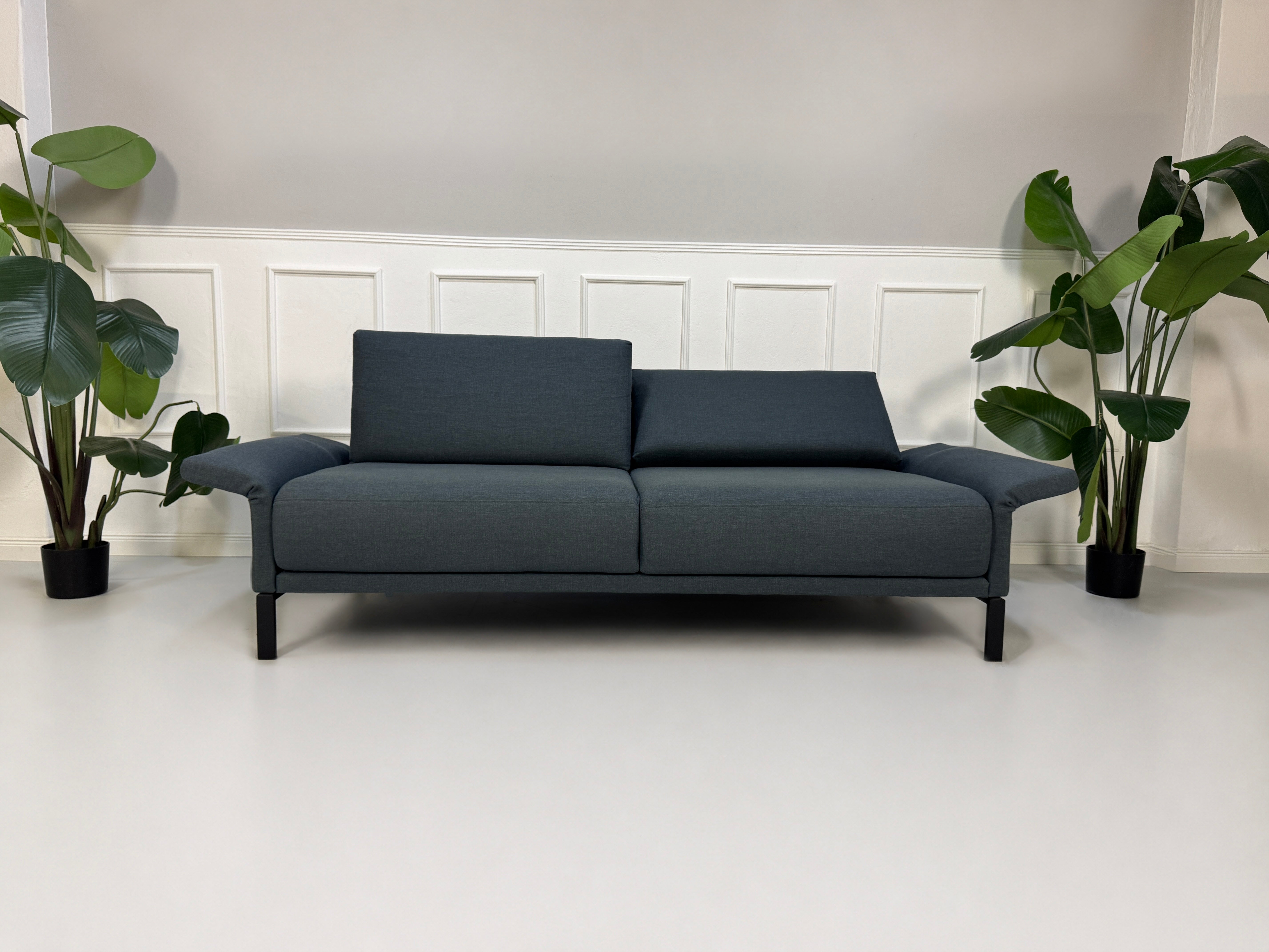Gebrauchte graue Rolf Benz Cara Designer Stoff Sofa Garnitur vor einer Wand, stilvoll und modern eingerichtet.