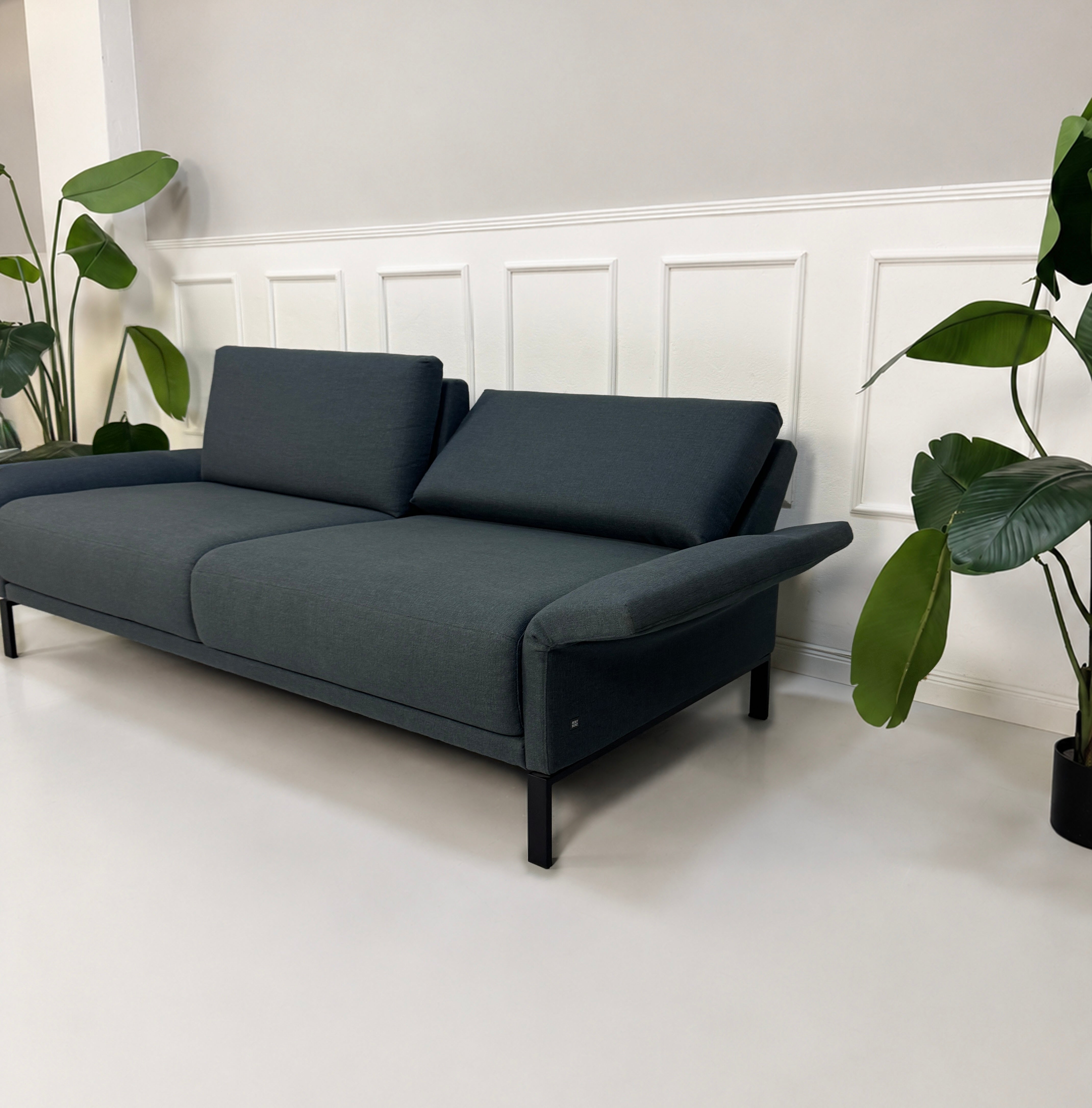 Gebrauchte graue Rolf Benz Cara Designer Stoff Sofa Garnitur vor einer Wand, stilvoll und modern eingerichtet.