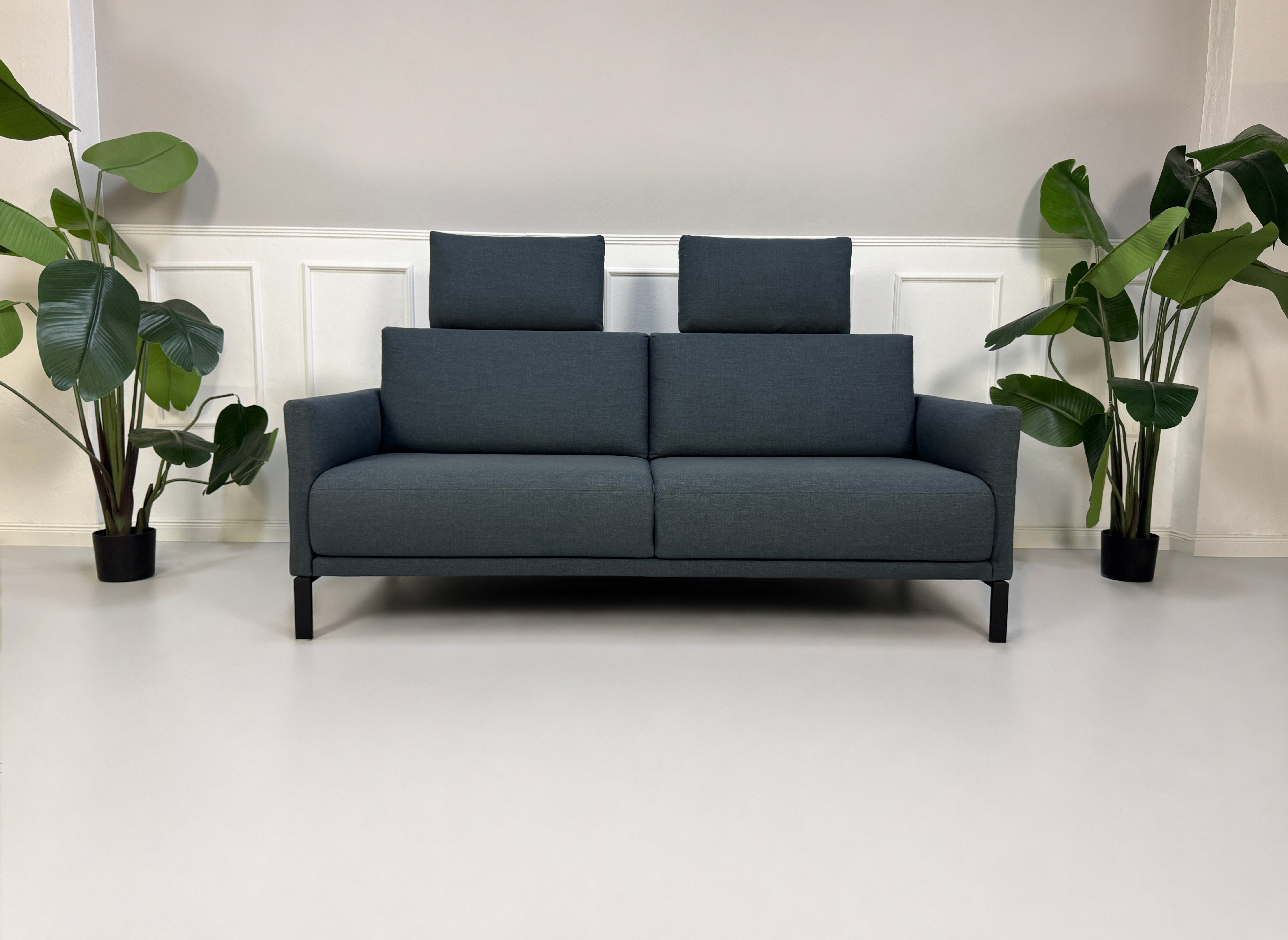 Gebrauchte graue Rolf Benz Cara Designer Stoff Sofa Garnitur vor einer Wand, stilvoll und modern eingerichtet.