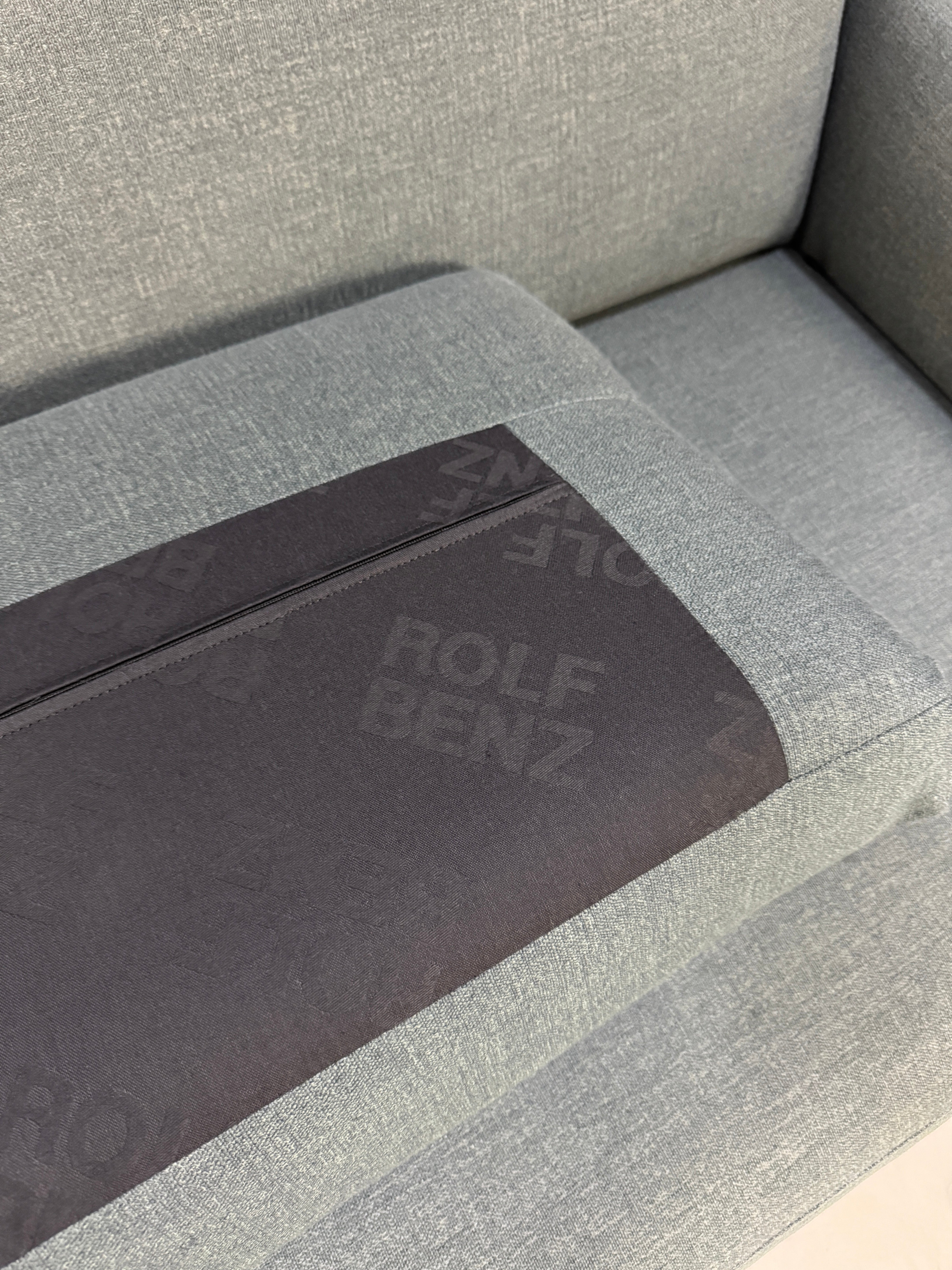 Gebrauchte graue Rolf Benz Cara Designer Stoff Sofa Garnitur vor einer Wand, stilvoll und modern eingerichtet.