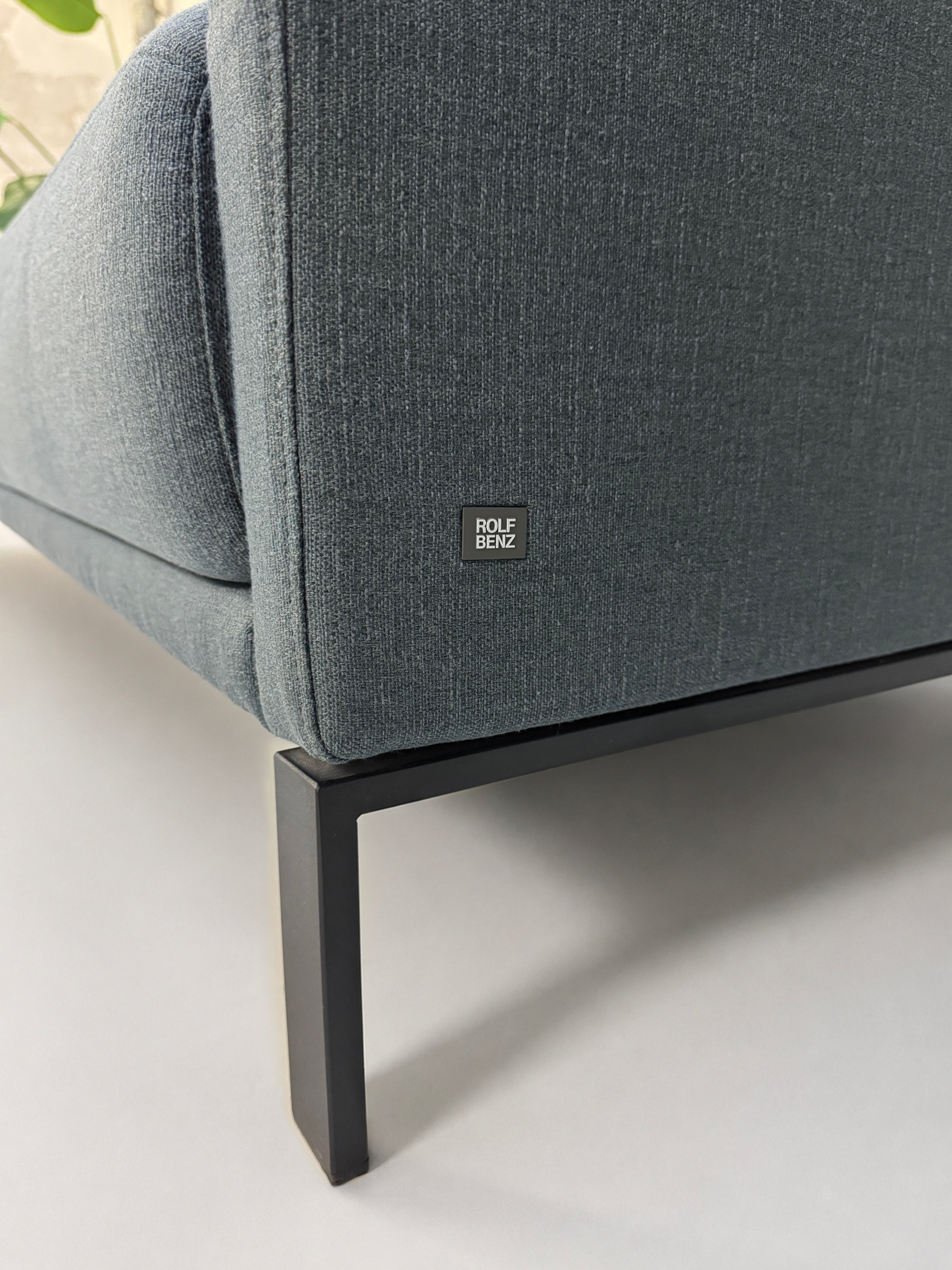 Gebrauchte graue Rolf Benz Cara Designer Stoff Sofa Garnitur vor einer Wand, stilvoll und modern eingerichtet.