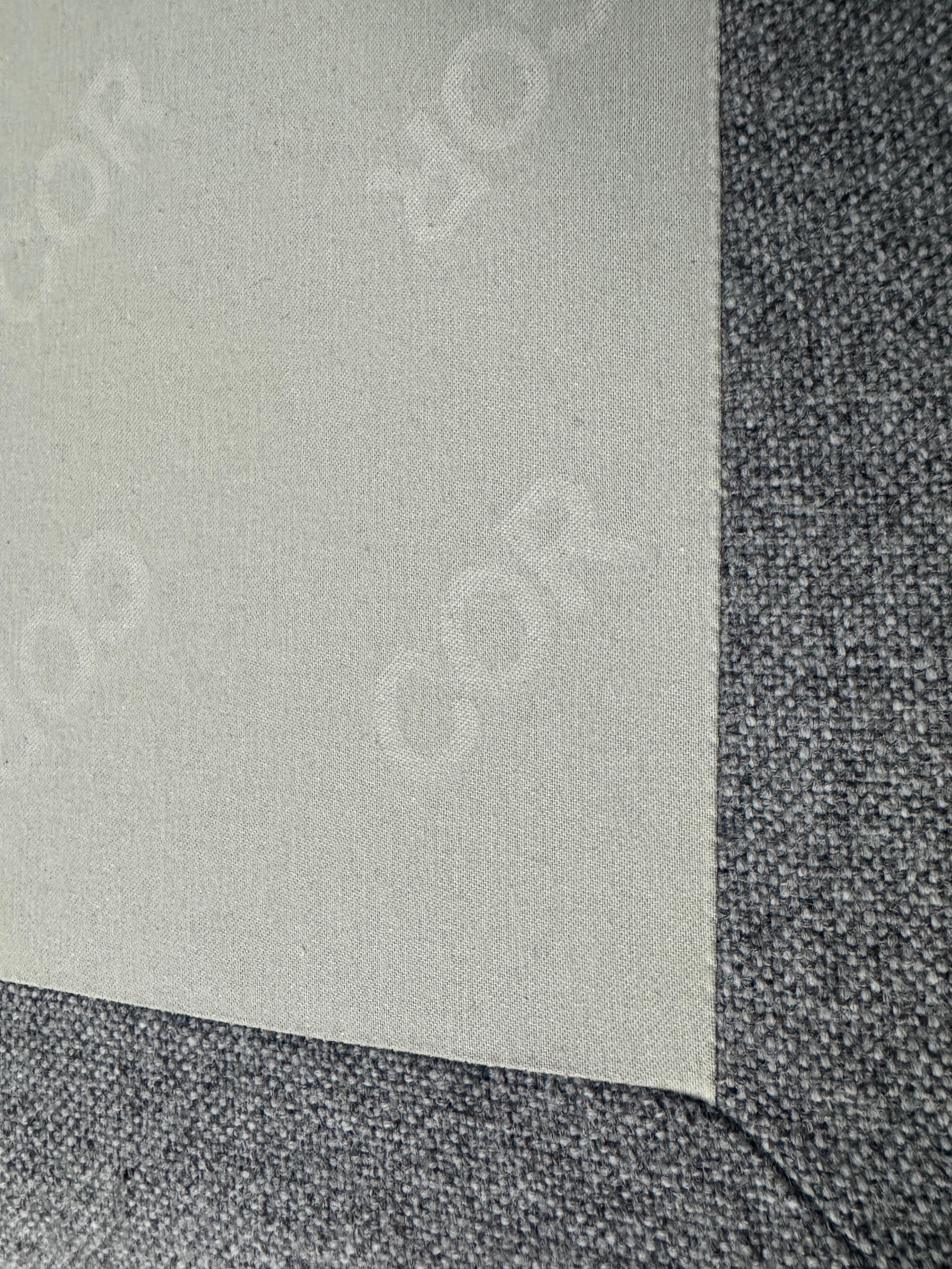 Gebrauchtes graues COR Conseta Designer Stoff Sofa vor einer Wand, stilvoll und modern eingerichtet.