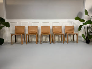 Gebrauchter beige brauner Cassina 412 CAB Designer Stuhl aus Leder vor einer Wand, stilvoll und modern eingerichtet.
