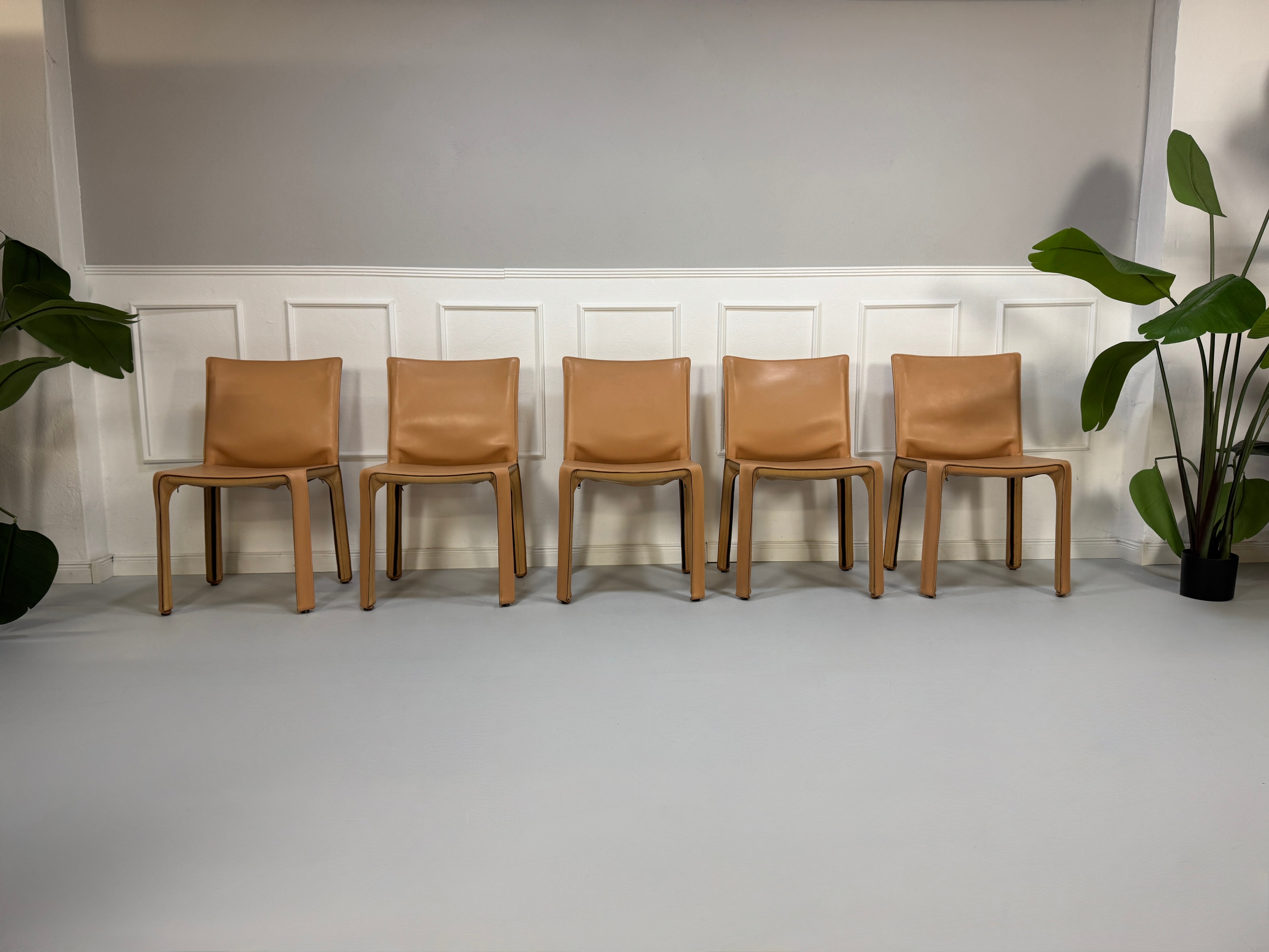 Gebrauchter beige brauner Cassina 412 CAB Designer Stuhl aus Leder vor einer Wand, stilvoll und modern eingerichtet.
