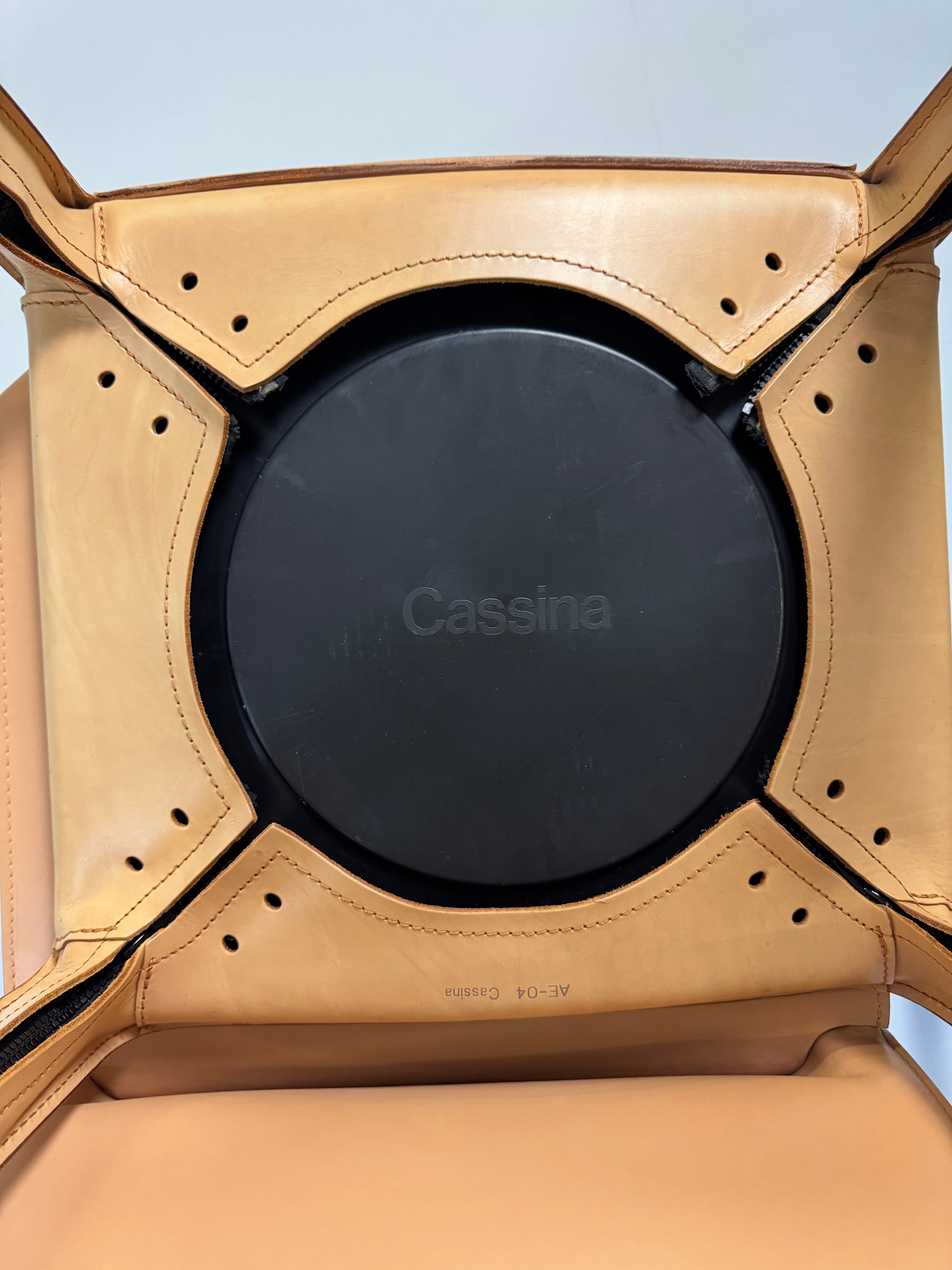 Gebrauchter beige brauner Cassina 412 CAB Designer Stuhl aus Leder vor einer Wand, stilvoll und modern eingerichtet.