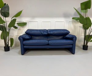 Gebrauchtes blaues Cassina Maralunga Designer Leder Sofa vor einer Wand, stilvoll und modern eingerichtet.