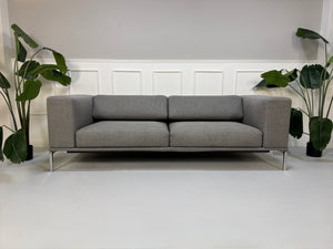 Gebrauchtes graues Cassina Moov Designer Stoff Sofa vor einer Wand, stilvoll und modern eingerichtet.