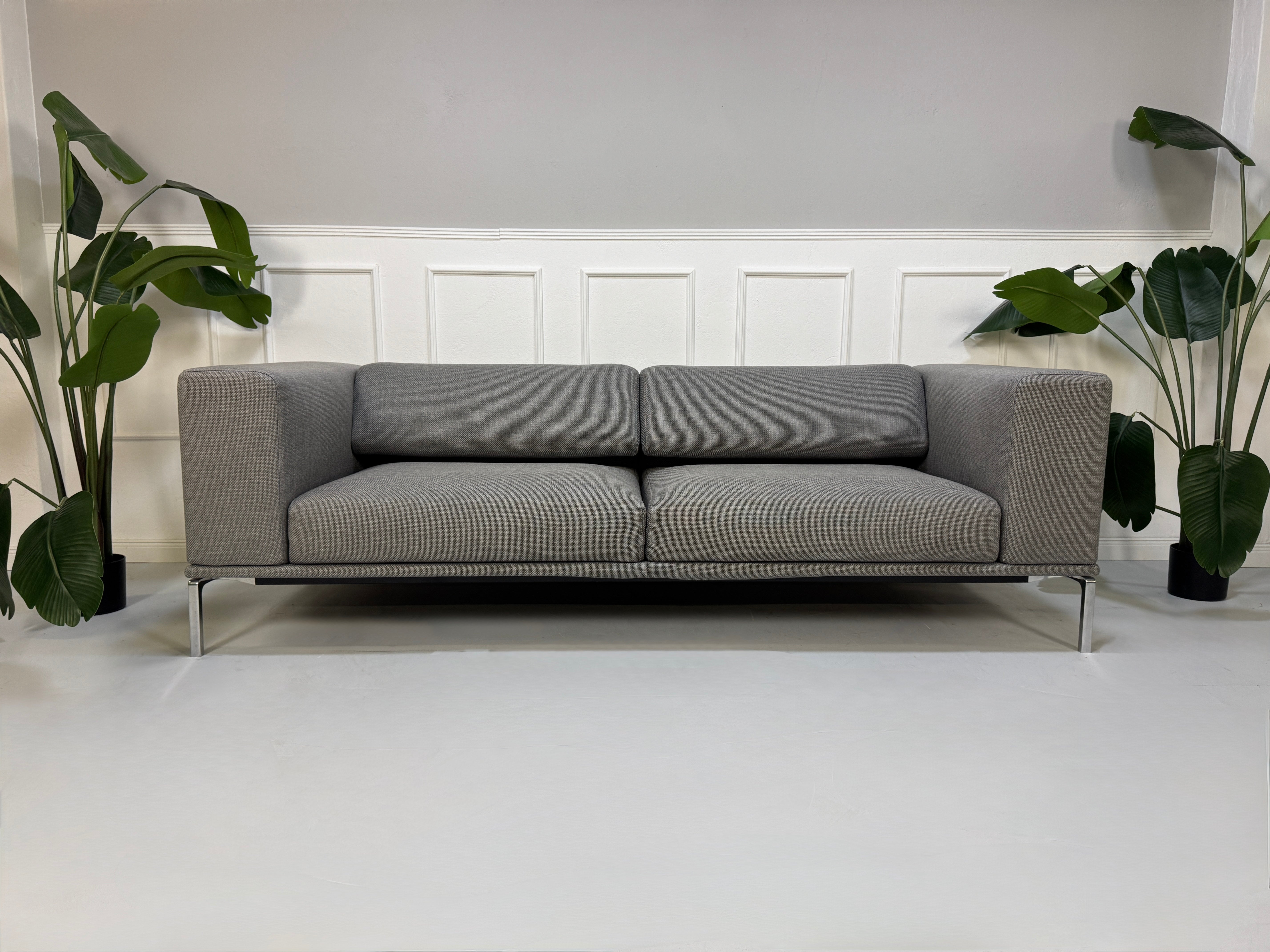 Gebrauchtes graues Cassina Moov Designer Stoff Sofa vor einer Wand, stilvoll und modern eingerichtet.
