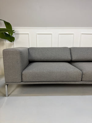 Gebrauchtes graues Cassina Moov Designer Stoff Sofa vor einer Wand, stilvoll und modern eingerichtet.