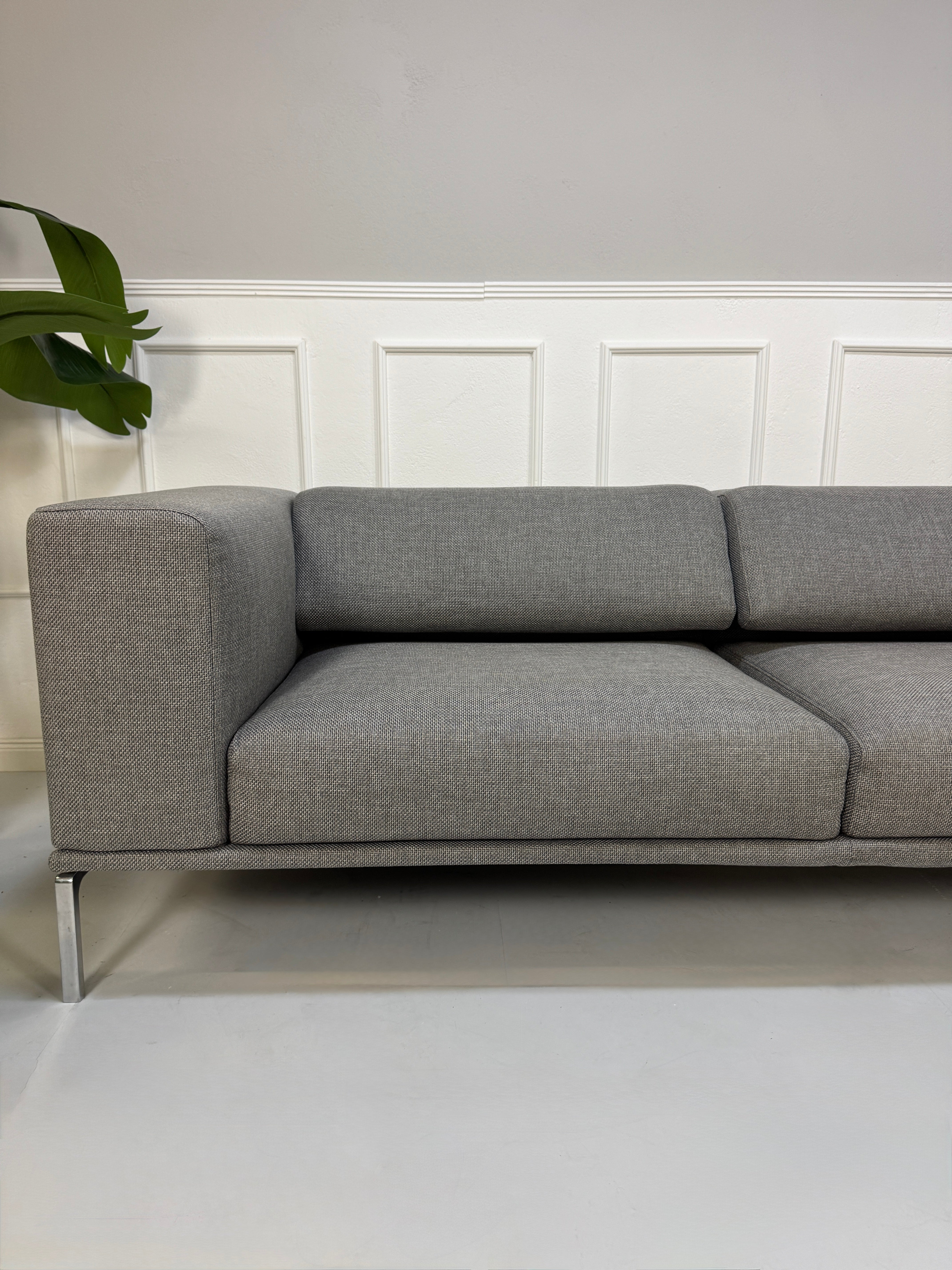 Gebrauchtes graues Cassina Moov Designer Stoff Sofa vor einer Wand, stilvoll und modern eingerichtet.