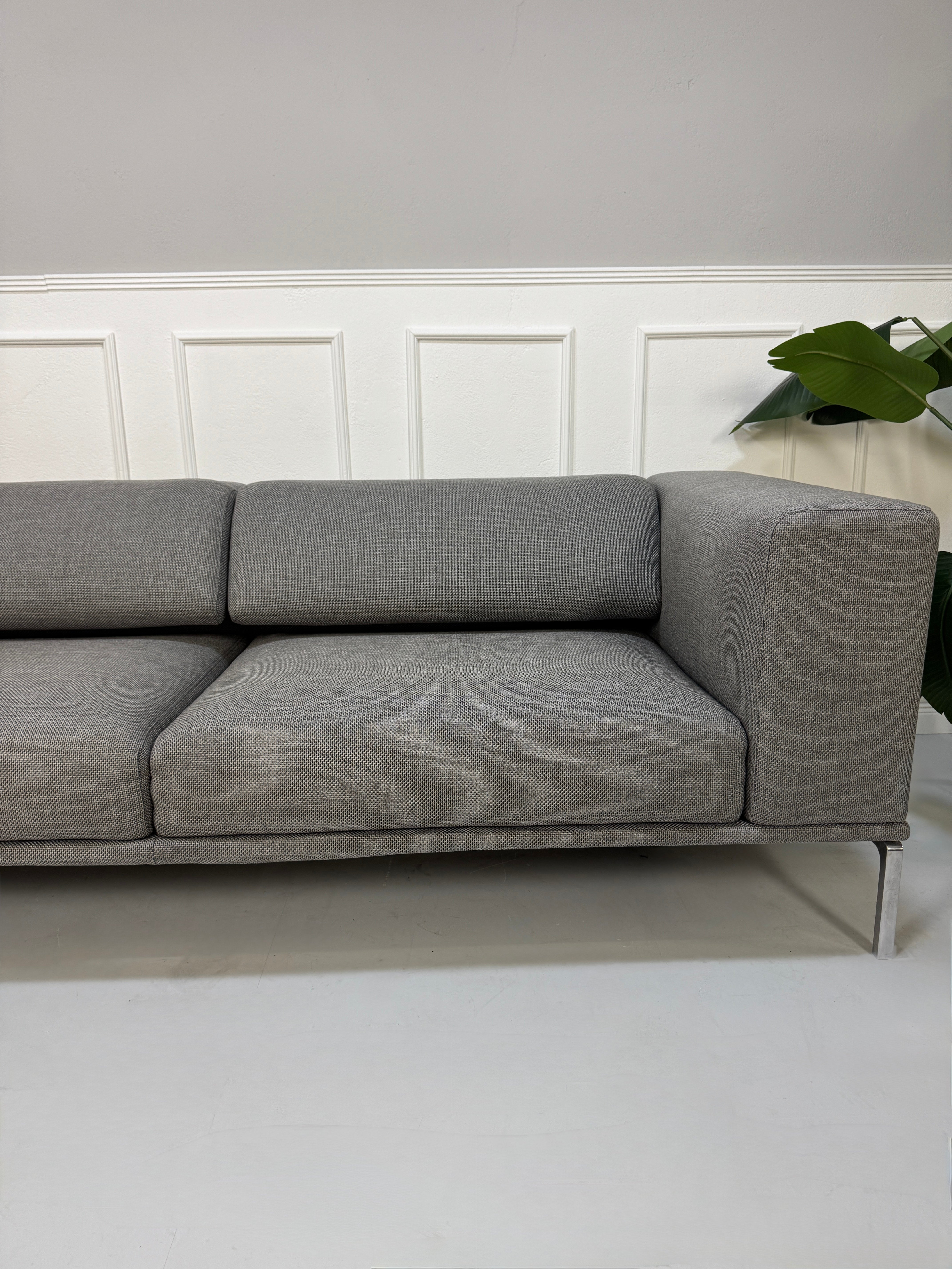 Gebrauchtes graues Cassina Moov Designer Stoff Sofa vor einer Wand, stilvoll und modern eingerichtet.