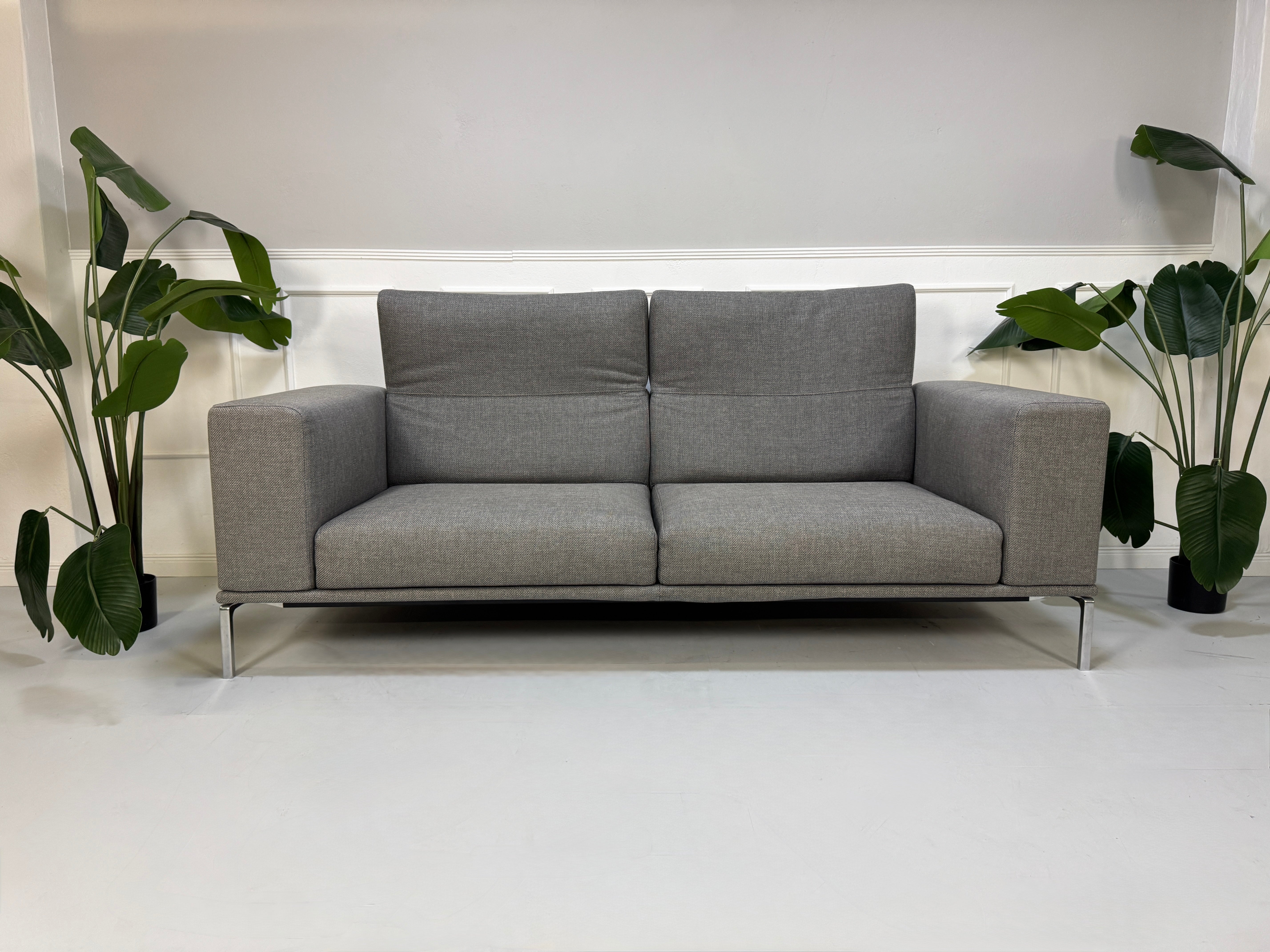 Gebrauchtes graues Cassina Moov Designer Stoff Sofa vor einer Wand, stilvoll und modern eingerichtet.