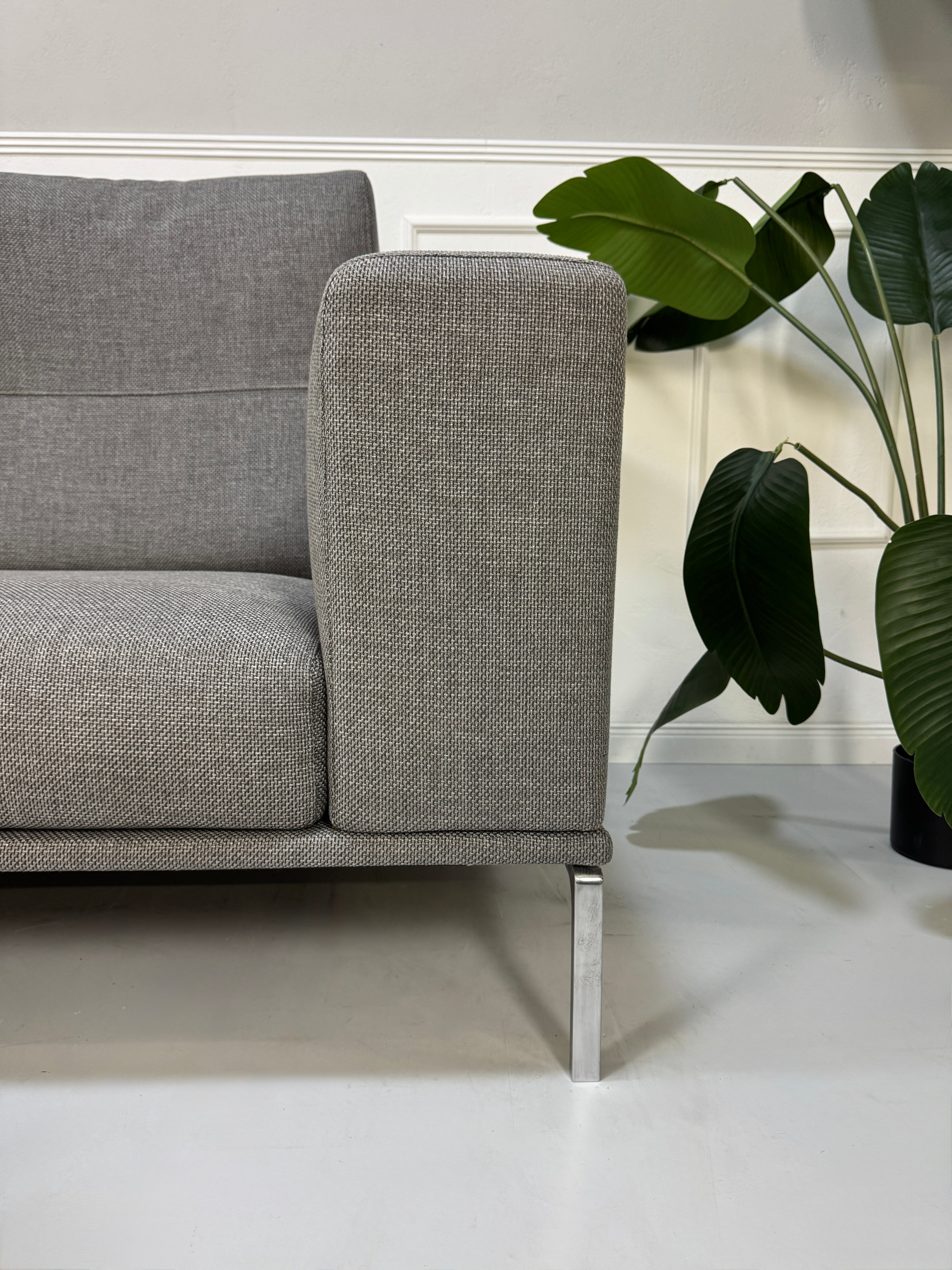 Gebrauchtes graues Cassina Moov Designer Stoff Sofa vor einer Wand, stilvoll und modern eingerichtet.