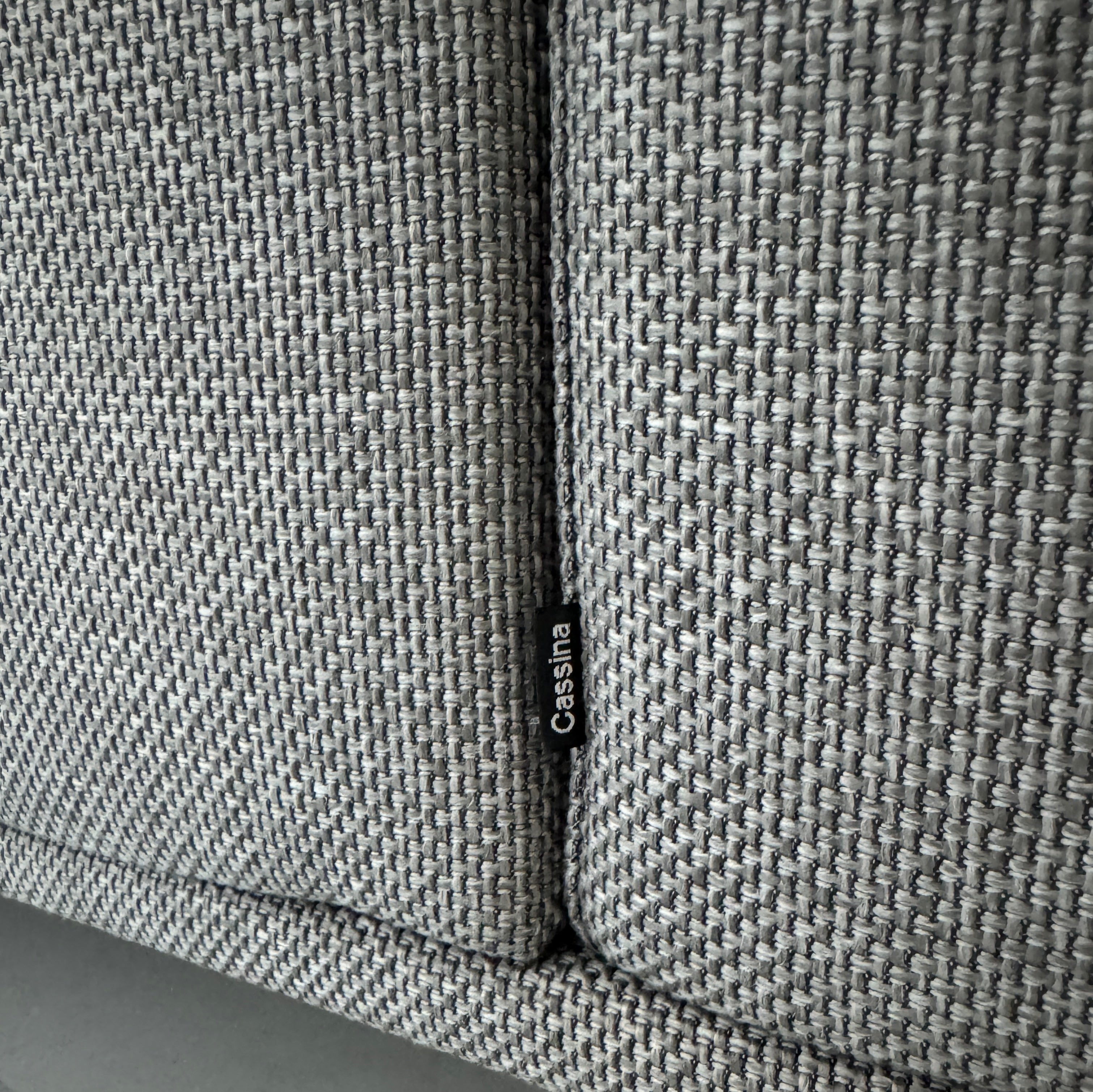 Gebrauchtes graues Cassina Moov Designer Stoff Sofa vor einer Wand, stilvoll und modern eingerichtet.