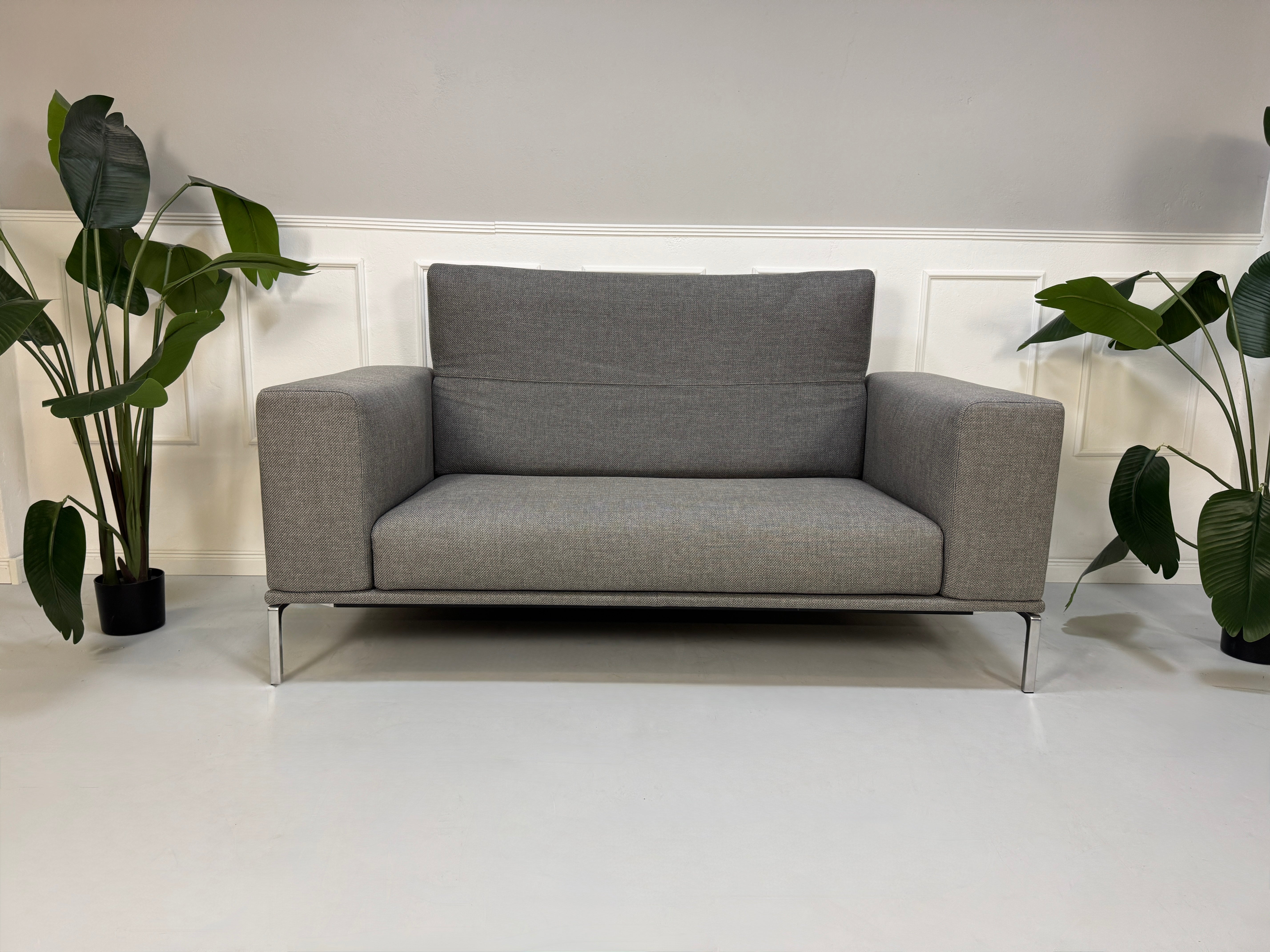 Gebrauchtes graues Cassina Moov Designer Stoff Sofa vor einer Wand, stilvoll und modern eingerichtet.