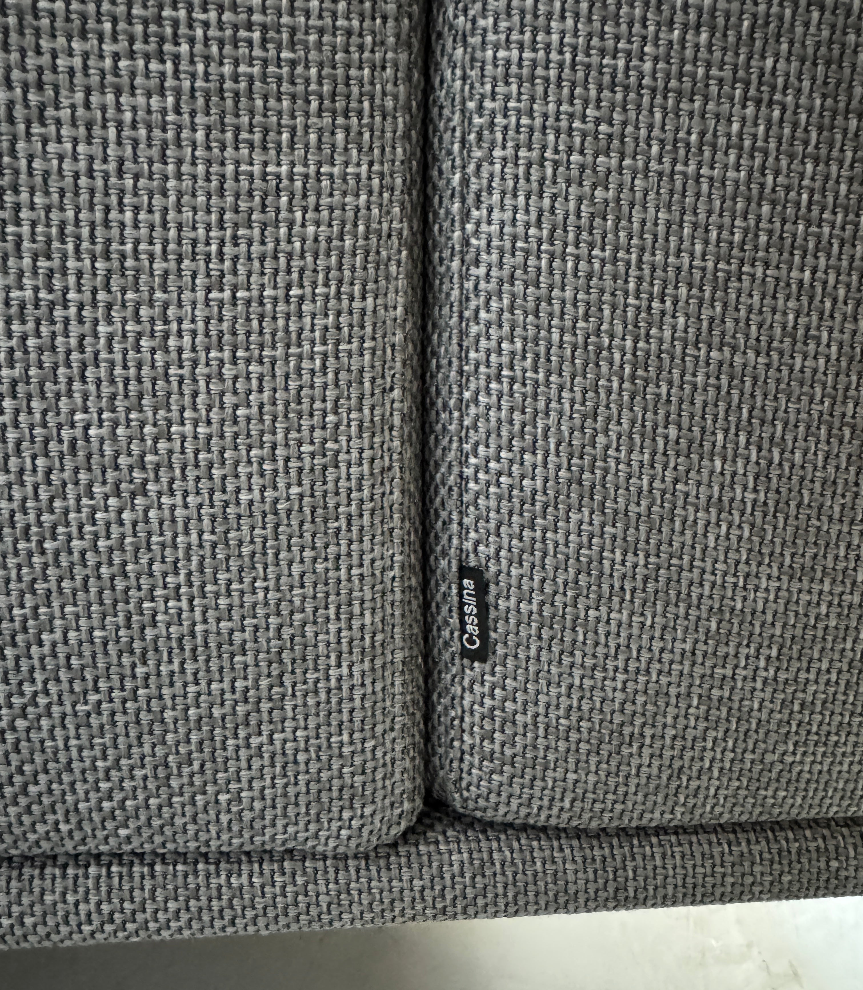 Gebrauchtes graues Cassina Moov Designer Stoff Sofa vor einer Wand, stilvoll und modern eingerichtet.