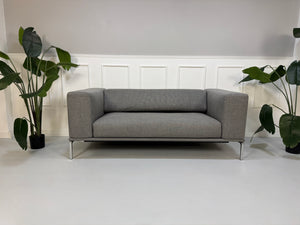 Gebrauchtes graues Cassina Moov Designer Stoff Sofa vor einer Wand, stilvoll und modern eingerichtet.