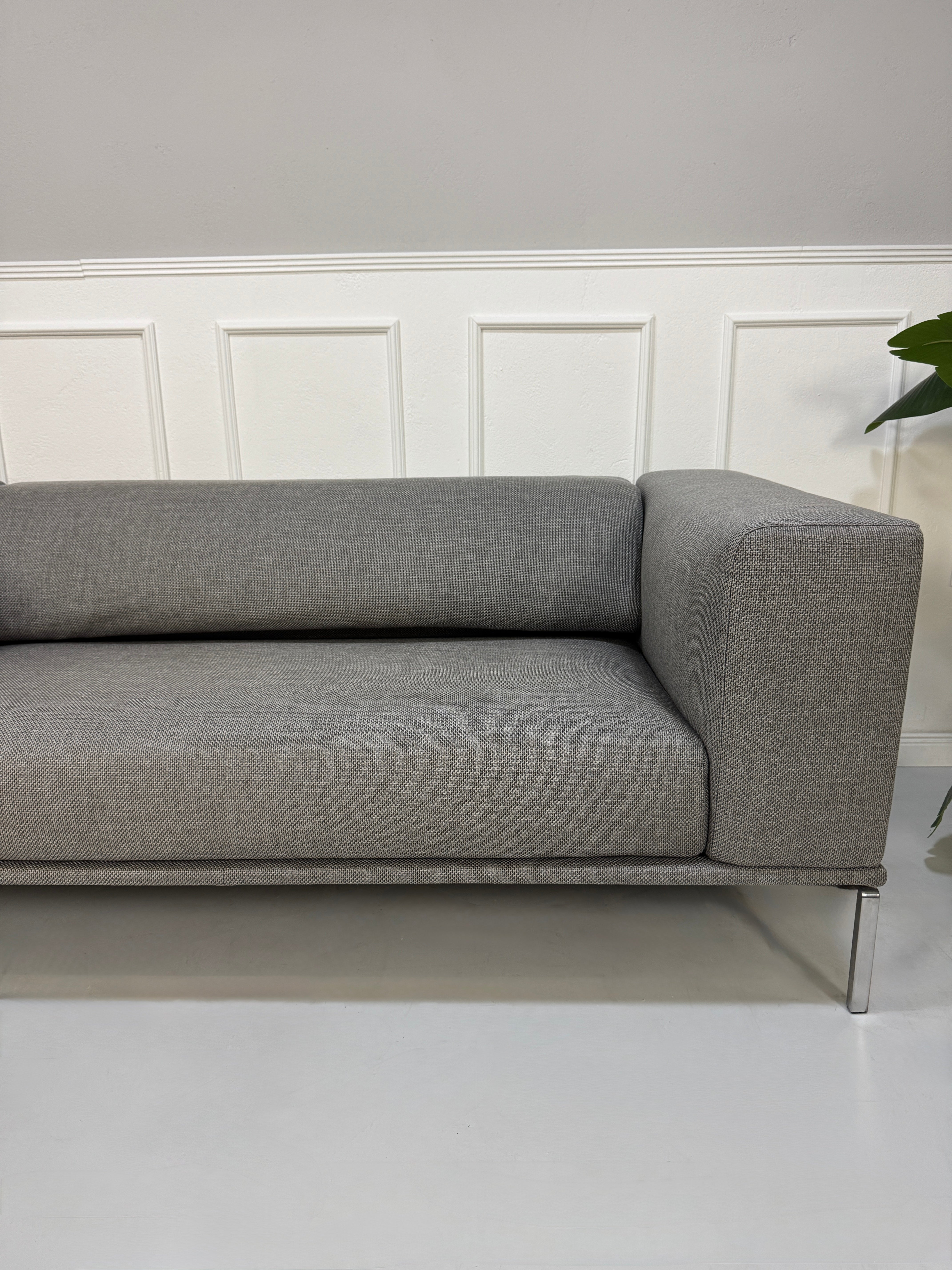 Gebrauchtes graues Cassina Moov Designer Stoff Sofa vor einer Wand, stilvoll und modern eingerichtet.