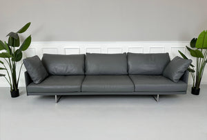 Gebrauchtes graues Cassina Toot Designer Leder Sofa vor einer Wand, stilvoll und modern eingerichtet.