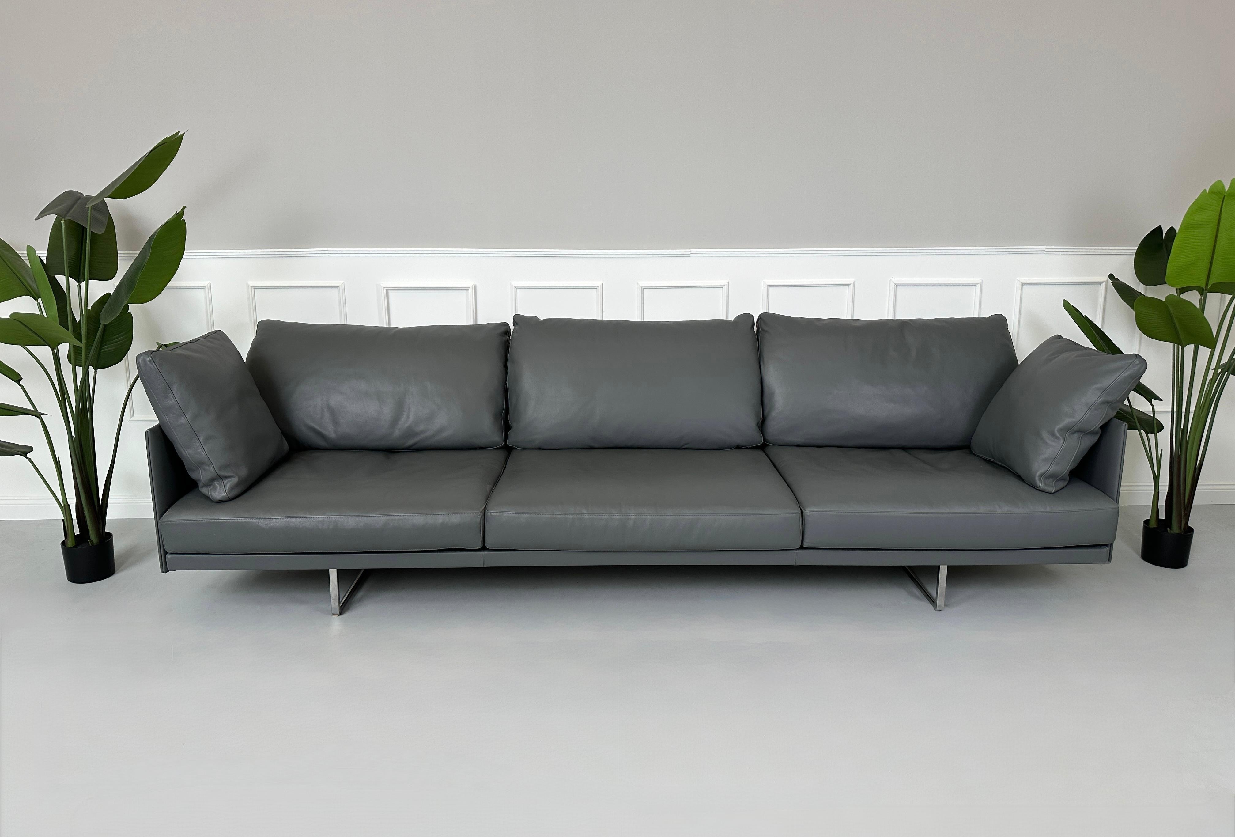 Gebrauchtes graues Cassina Toot Designer Leder Sofa vor einer Wand, stilvoll und modern eingerichtet.