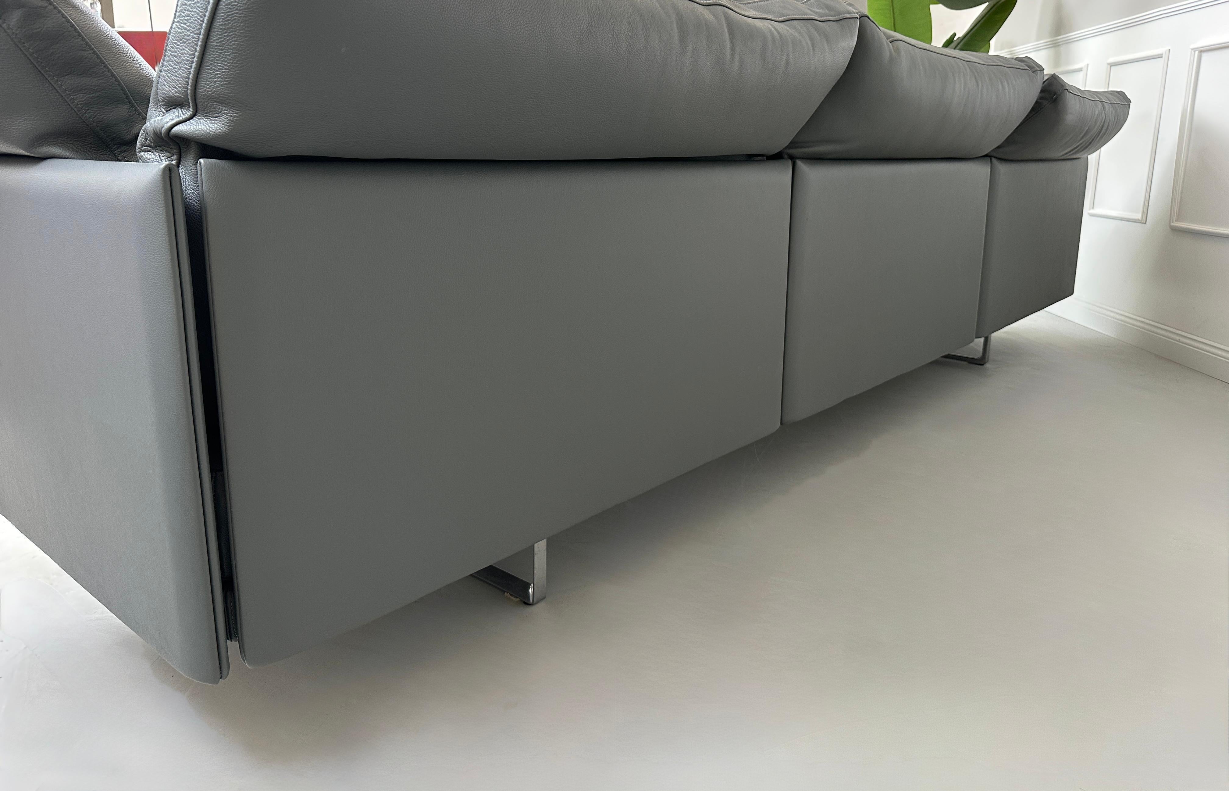 Gebrauchtes graues Cassina Toot Designer Leder Sofa vor einer Wand, stilvoll und modern eingerichtet.